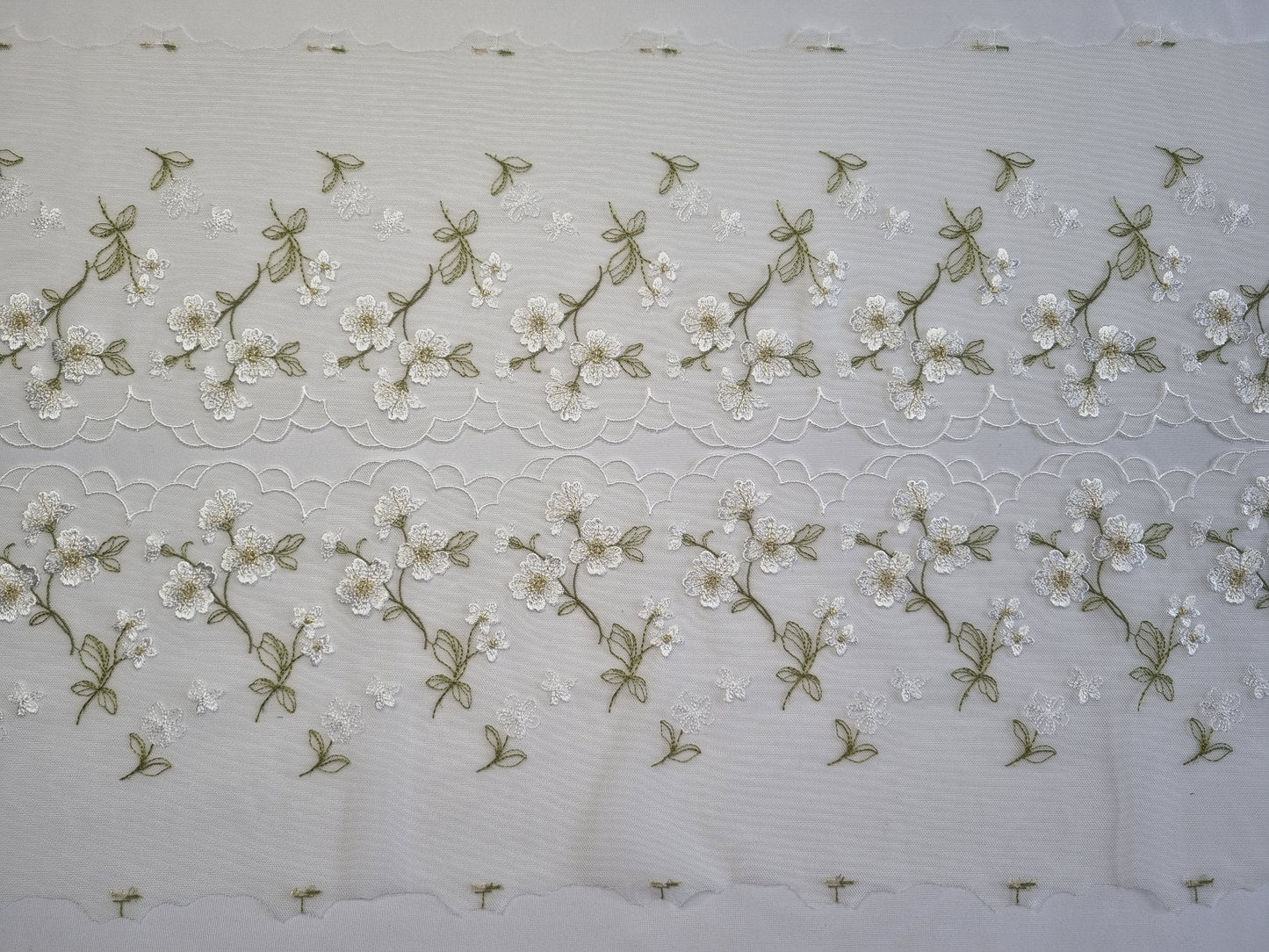 Wit tule kant met geborduurde, witte bloemen
