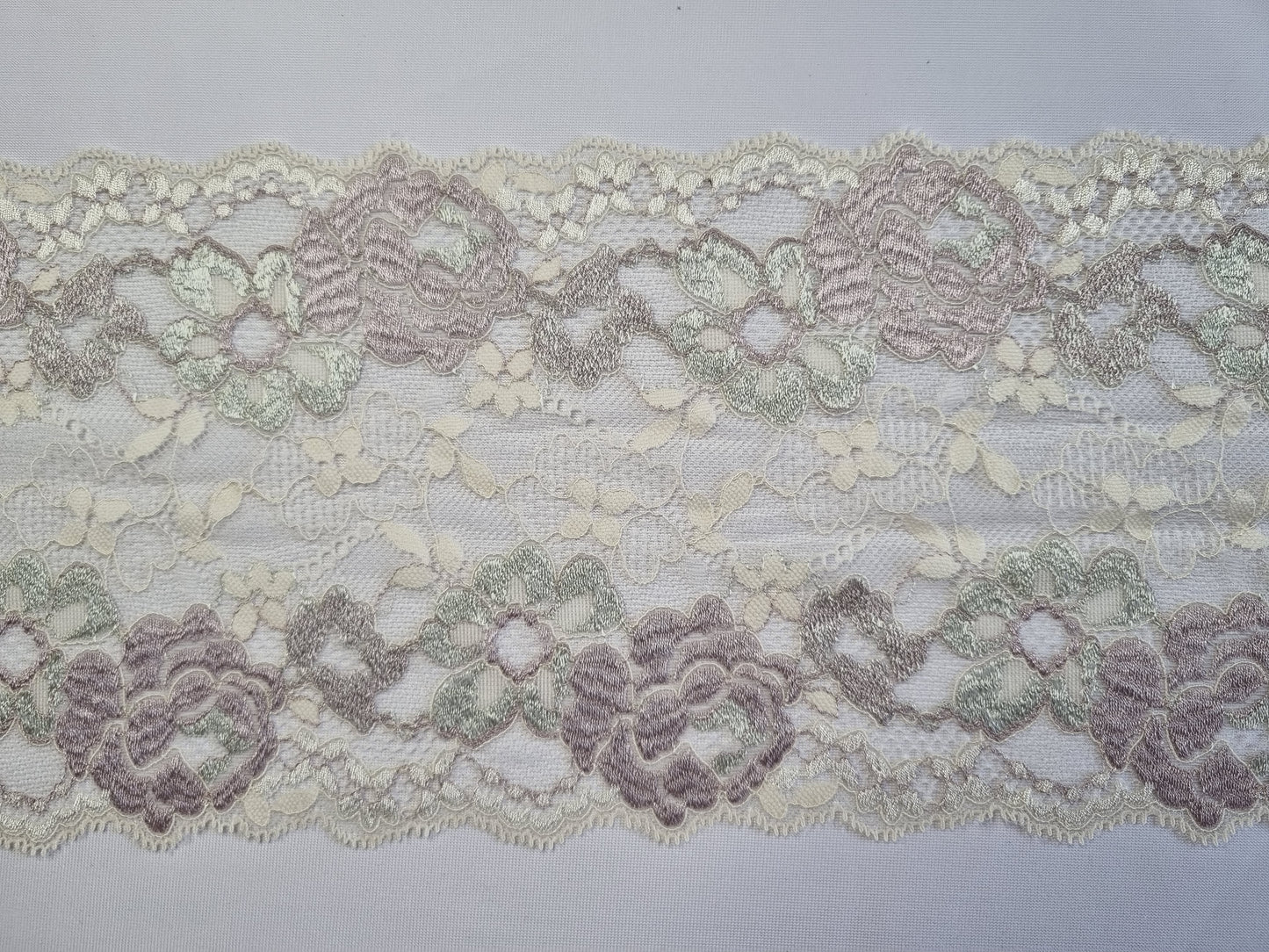 Ivoor stretchkant met ingeweven rozen in zacht vintage roze en groen
