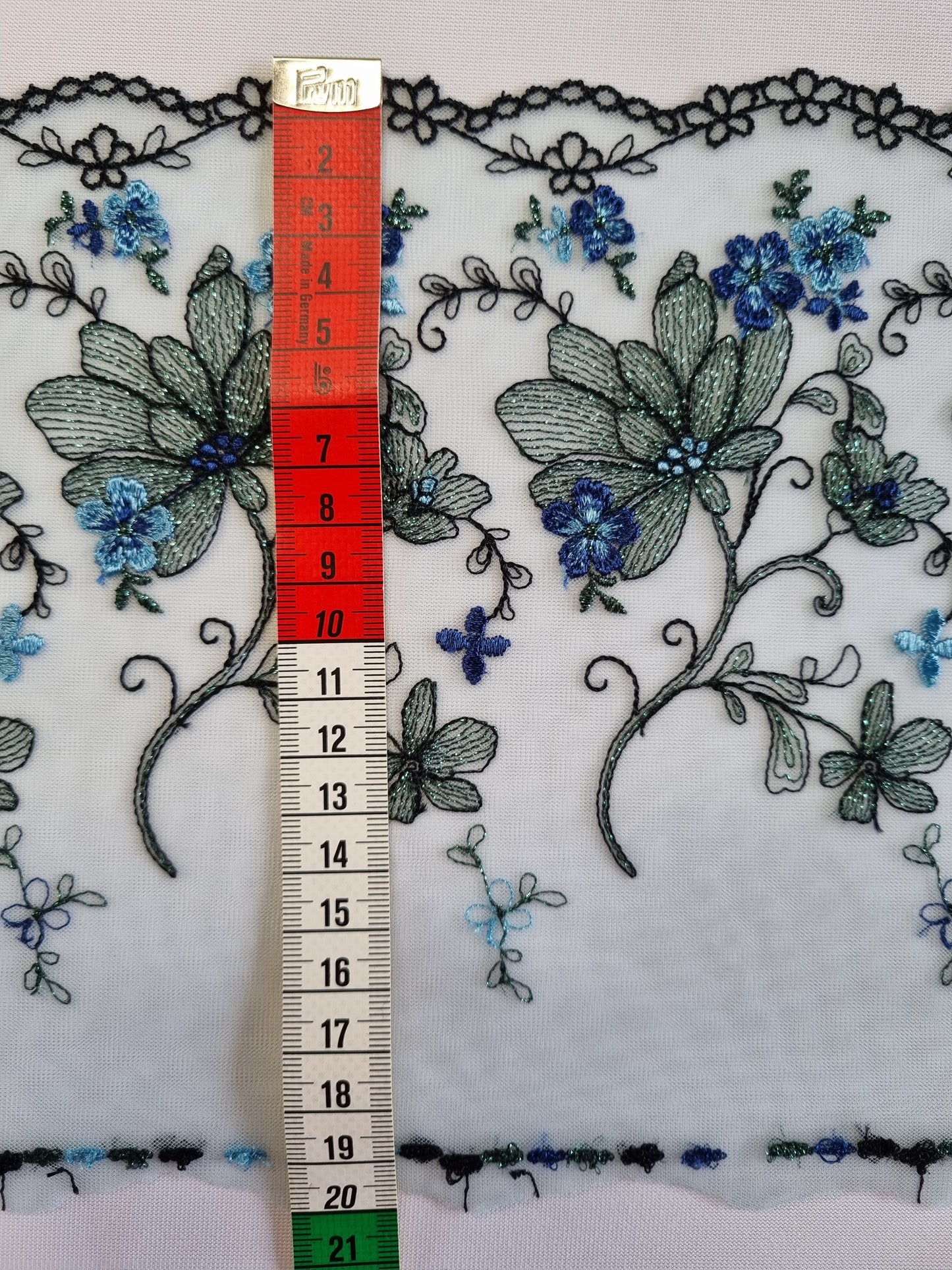 Lichtblauw tule kant met vergeet-mij-nietjes en bloemen in lichtblauw lurex draad