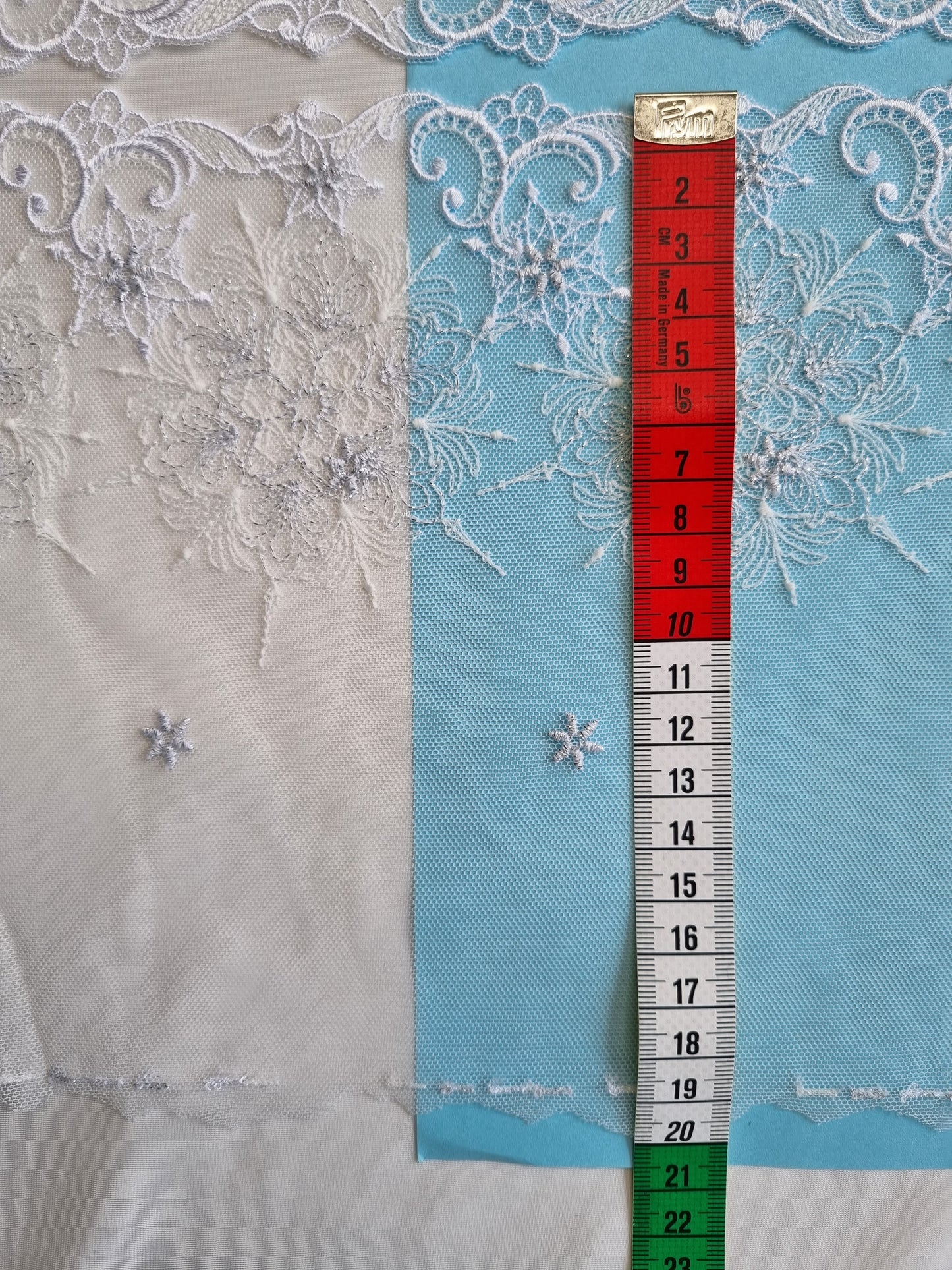 Wit tule kant met geborduurde sneeuwvlokken