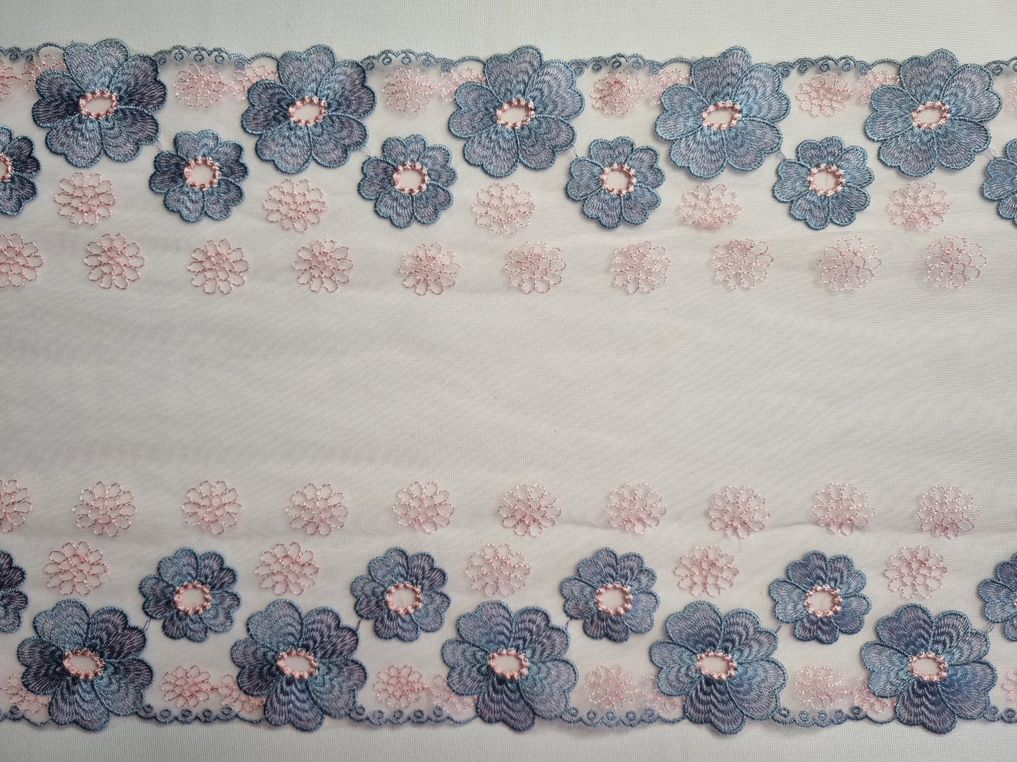 Roze tule kant met blauw geborduurde bloemen