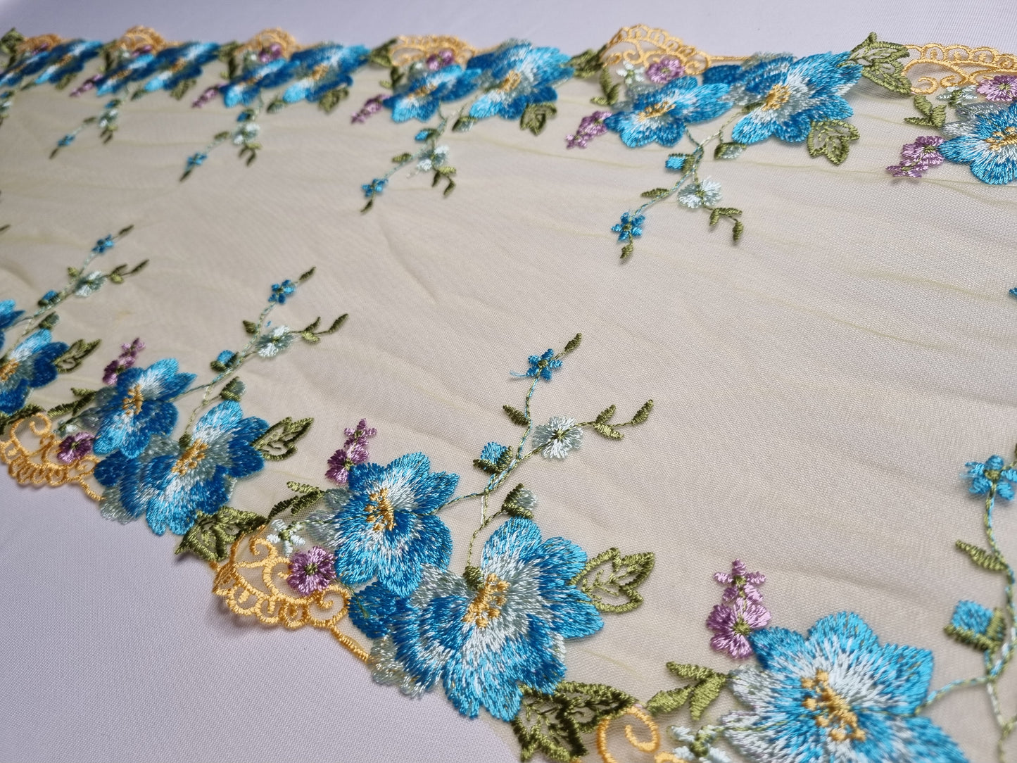 Olijf kleurig tule kant met blauw geborduurde bloemen