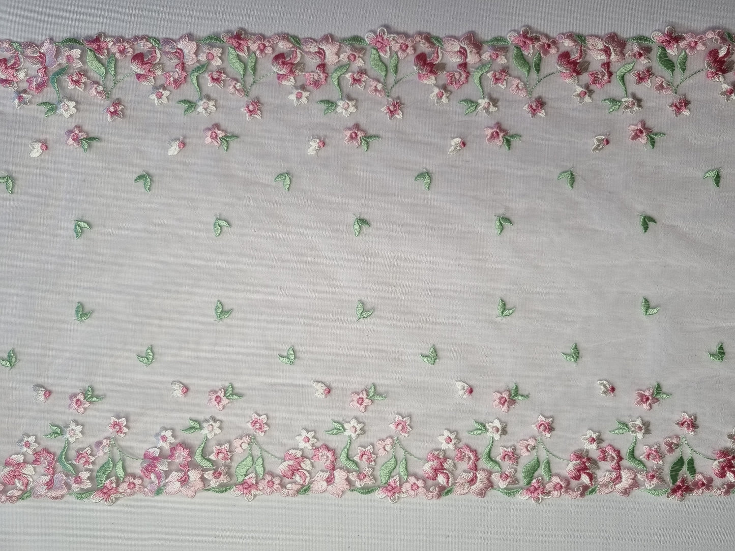 Roze tule kant met klein, roze, geborduurde bloesem