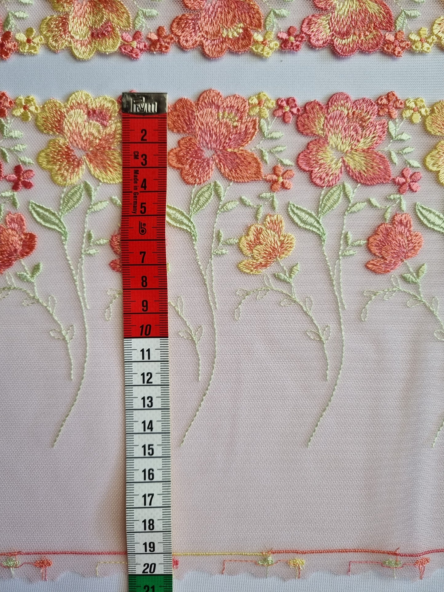 Peach kleurig tule kant met peach en zacht geel geborduurde roosjes