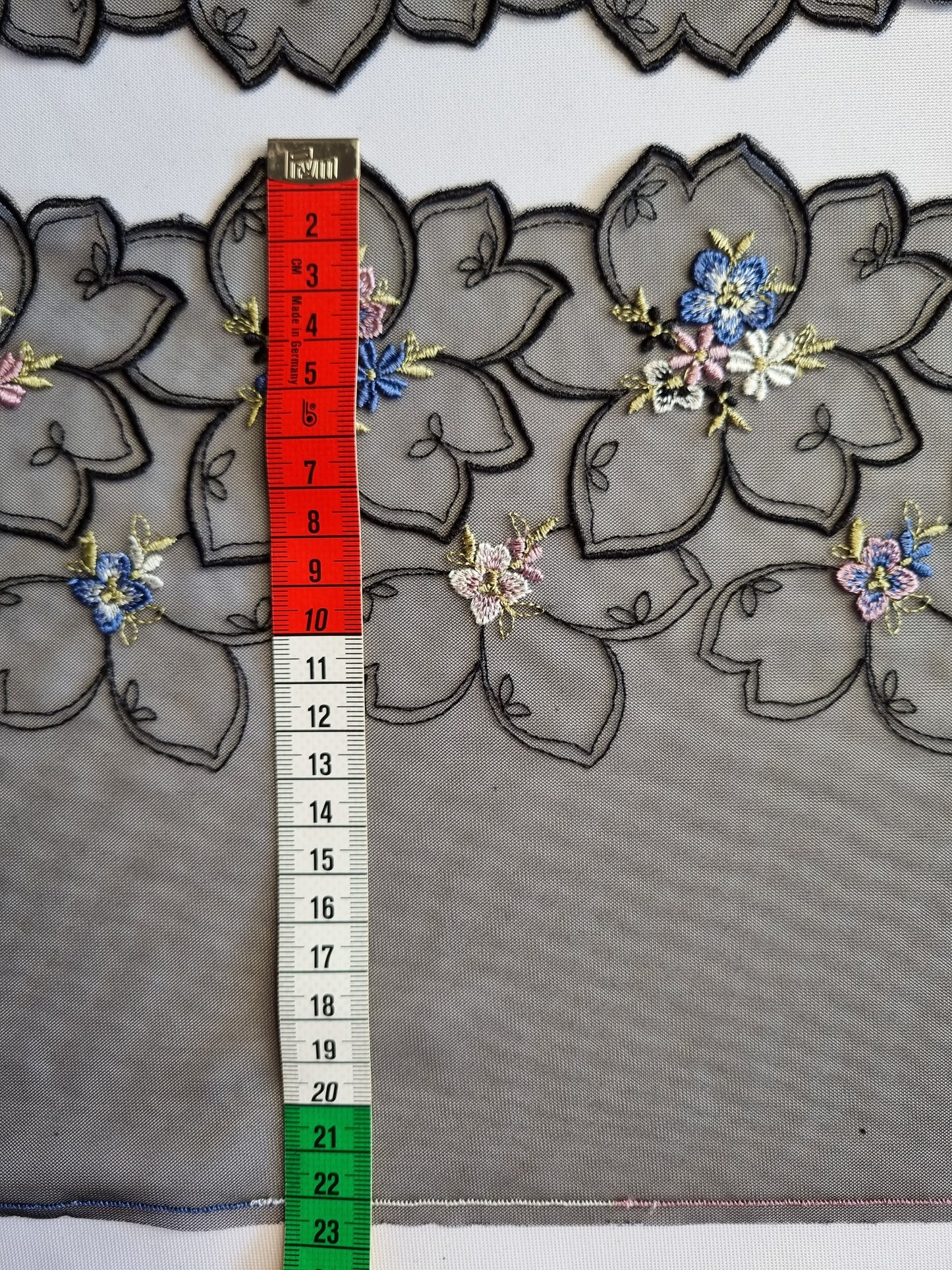 Zwart tule kant met grote zwarte bloemen en kleine vergeet-me-nietjes