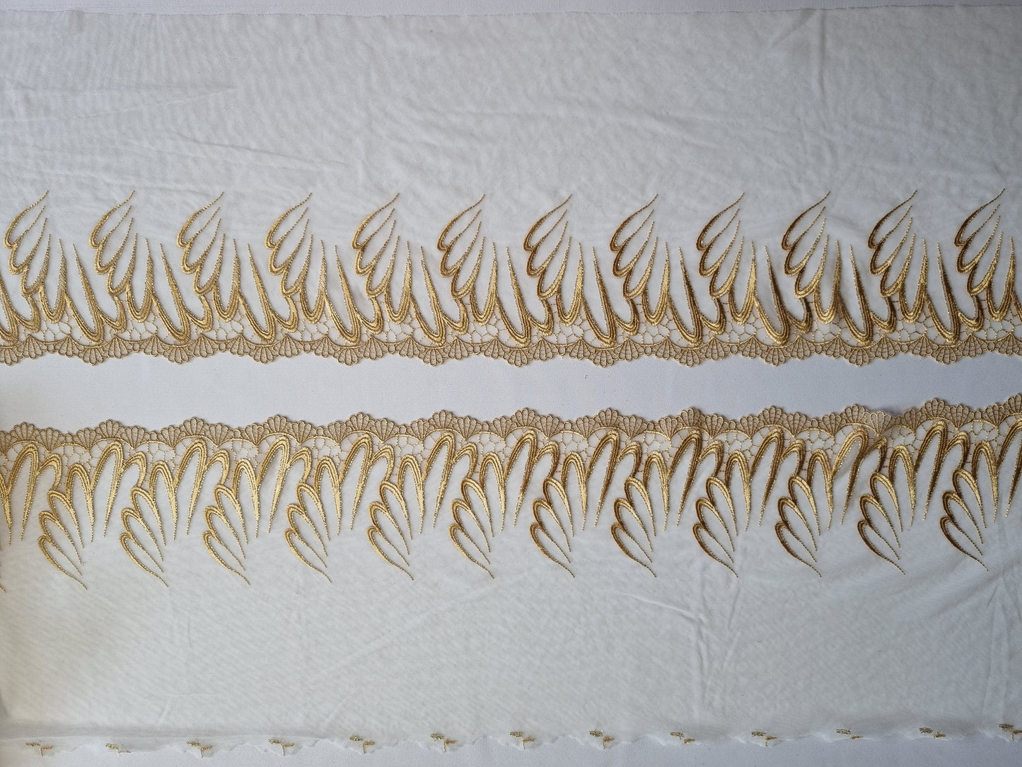 Wit tule kant met goudkleurig borduursel