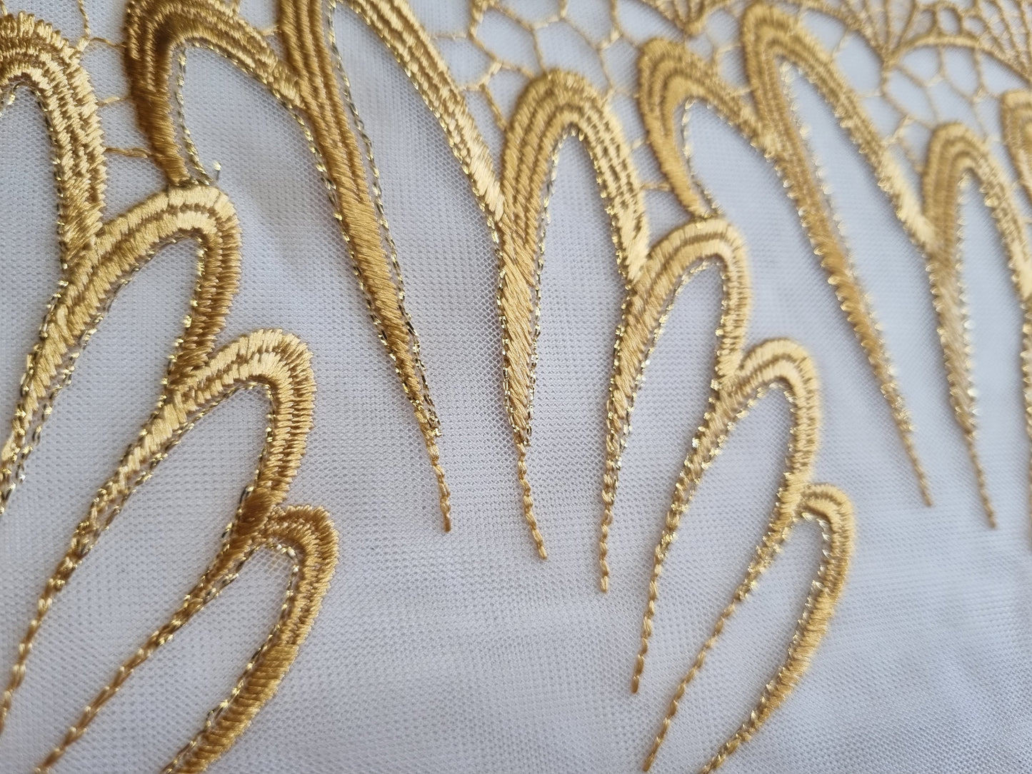 Wit tule kant met goudkleurig borduursel