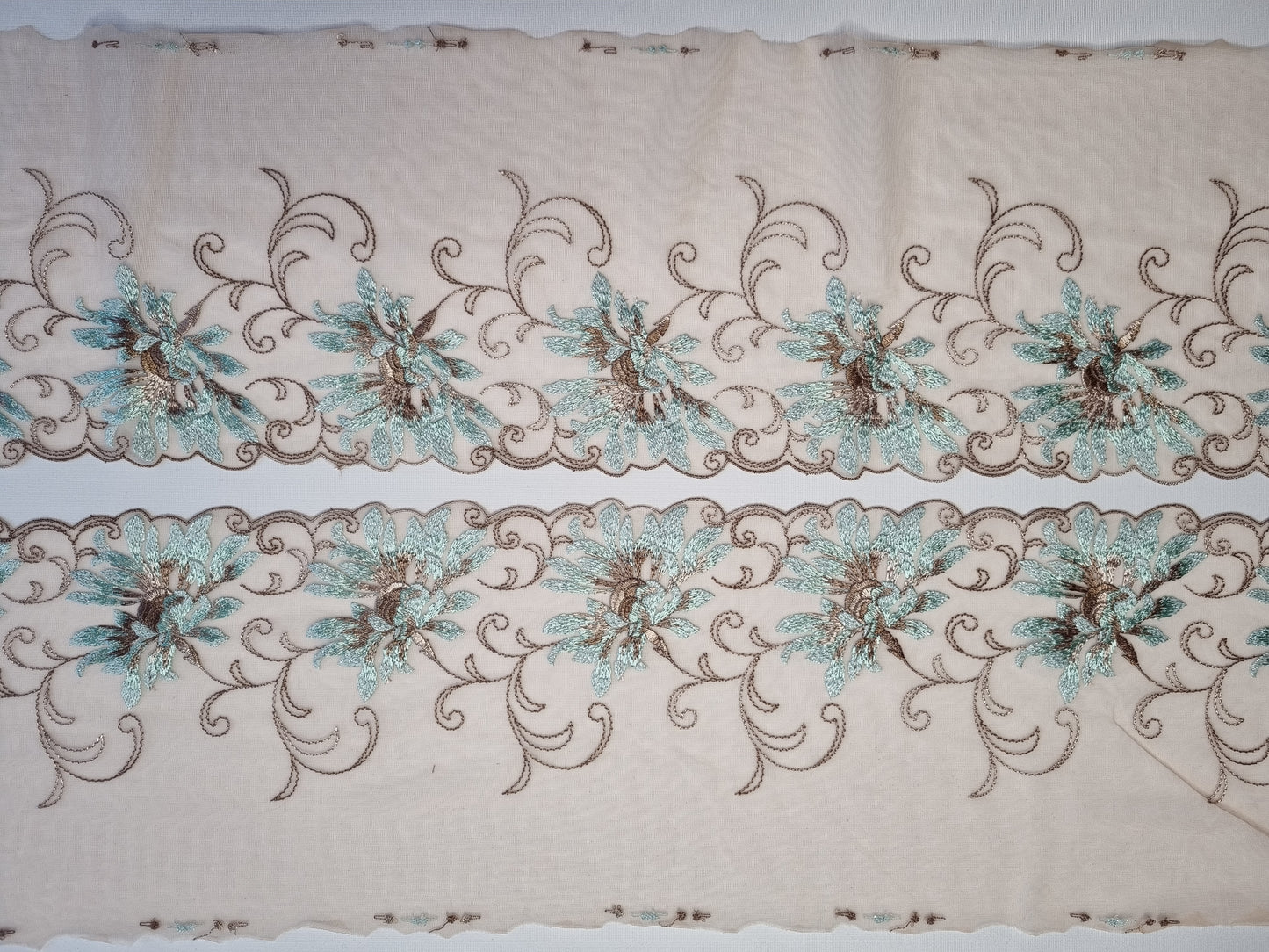 Latte tule kant met korenbloemen voorzien van lichtblauw lurex draad