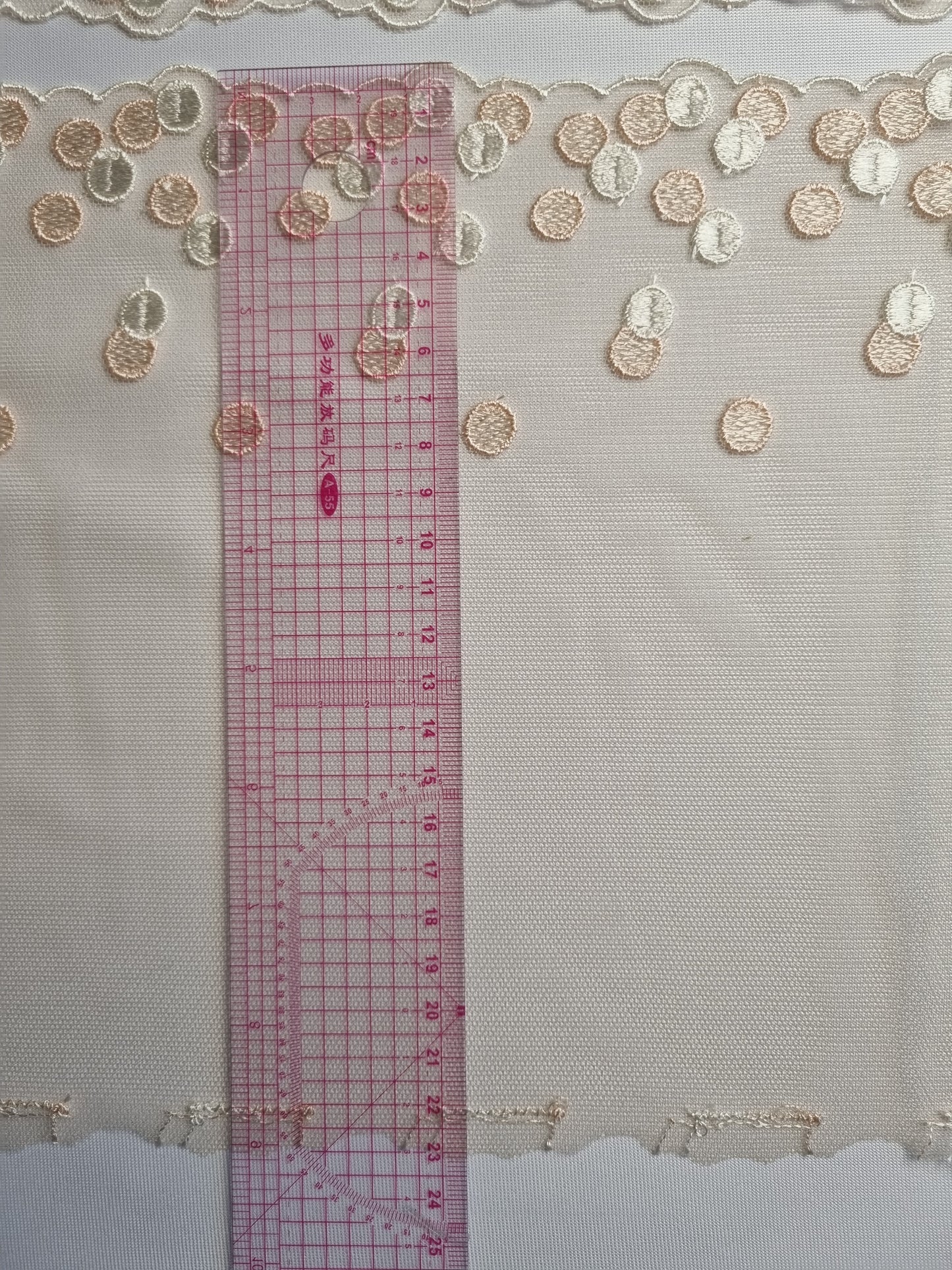 Beige kleurig tule kant met polka dots in peach en crème