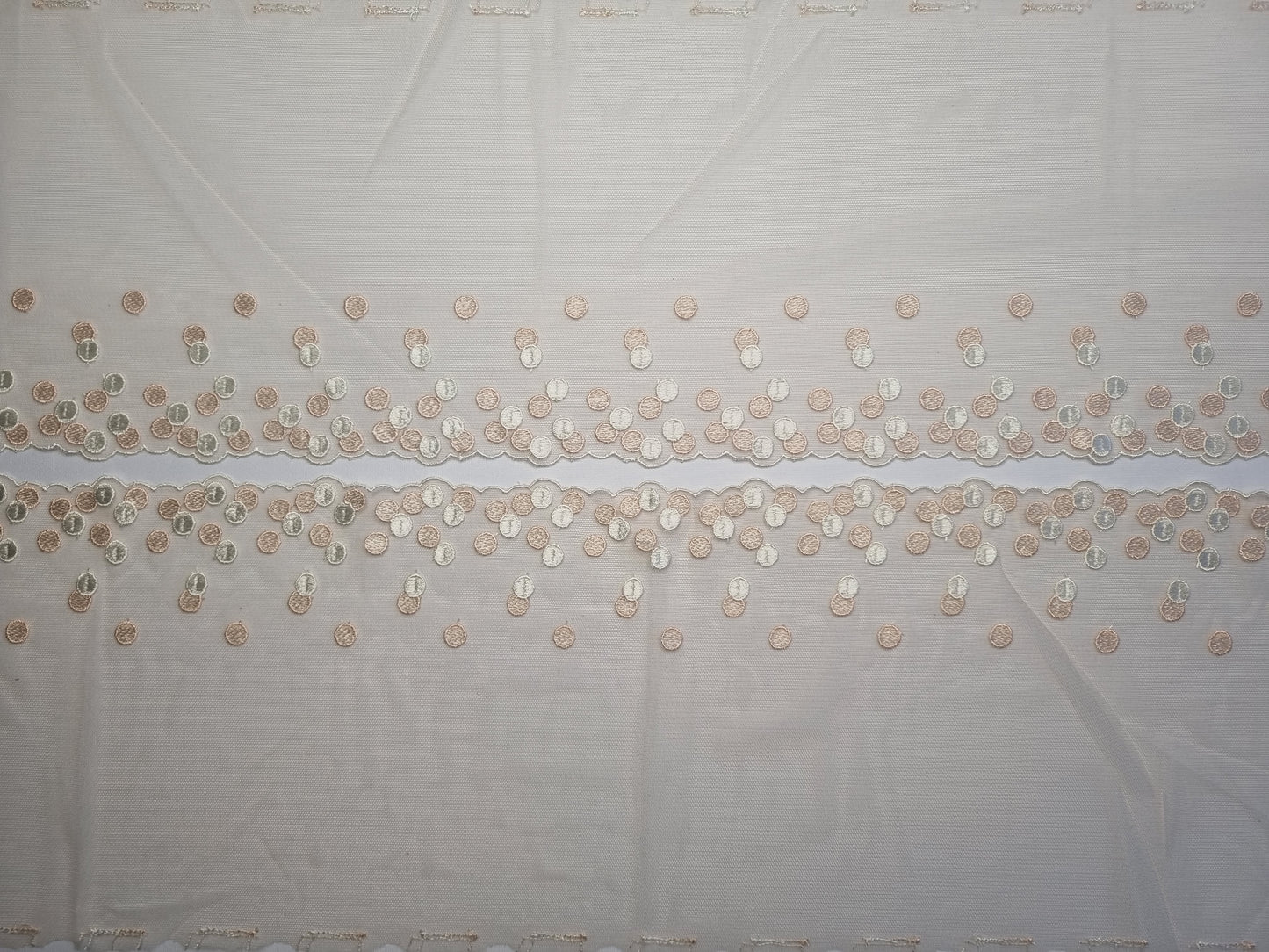 Beige kleurig tule kant met polka dots in peach en crème
