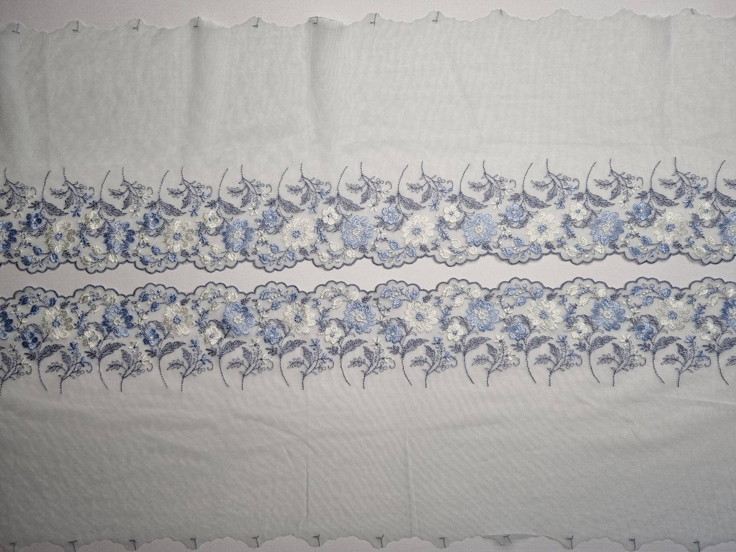 Mint kleurig tule kant met lavendelblauw en wit geborduurde bloemen