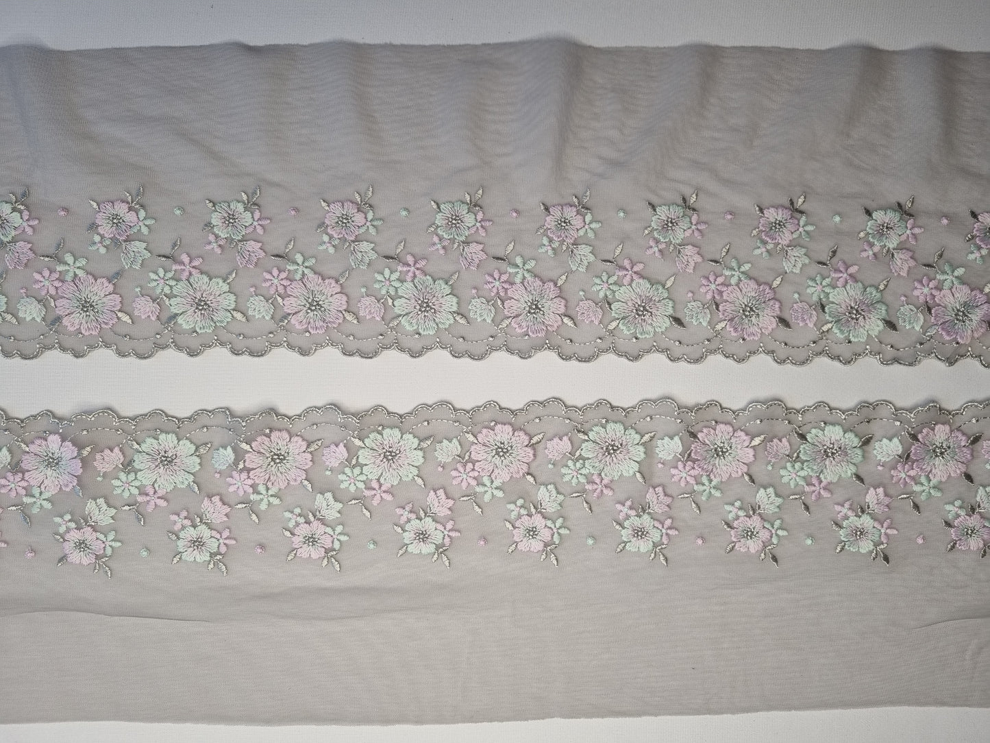 Parelgrijs tule kant met roze en wit geborduurde bloesem