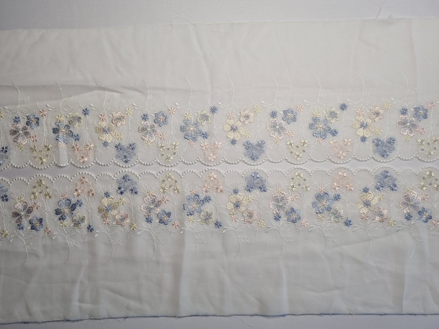 Geborduurd kant op geweven chiffon in crème wit met pastelkleurige bloemetjes