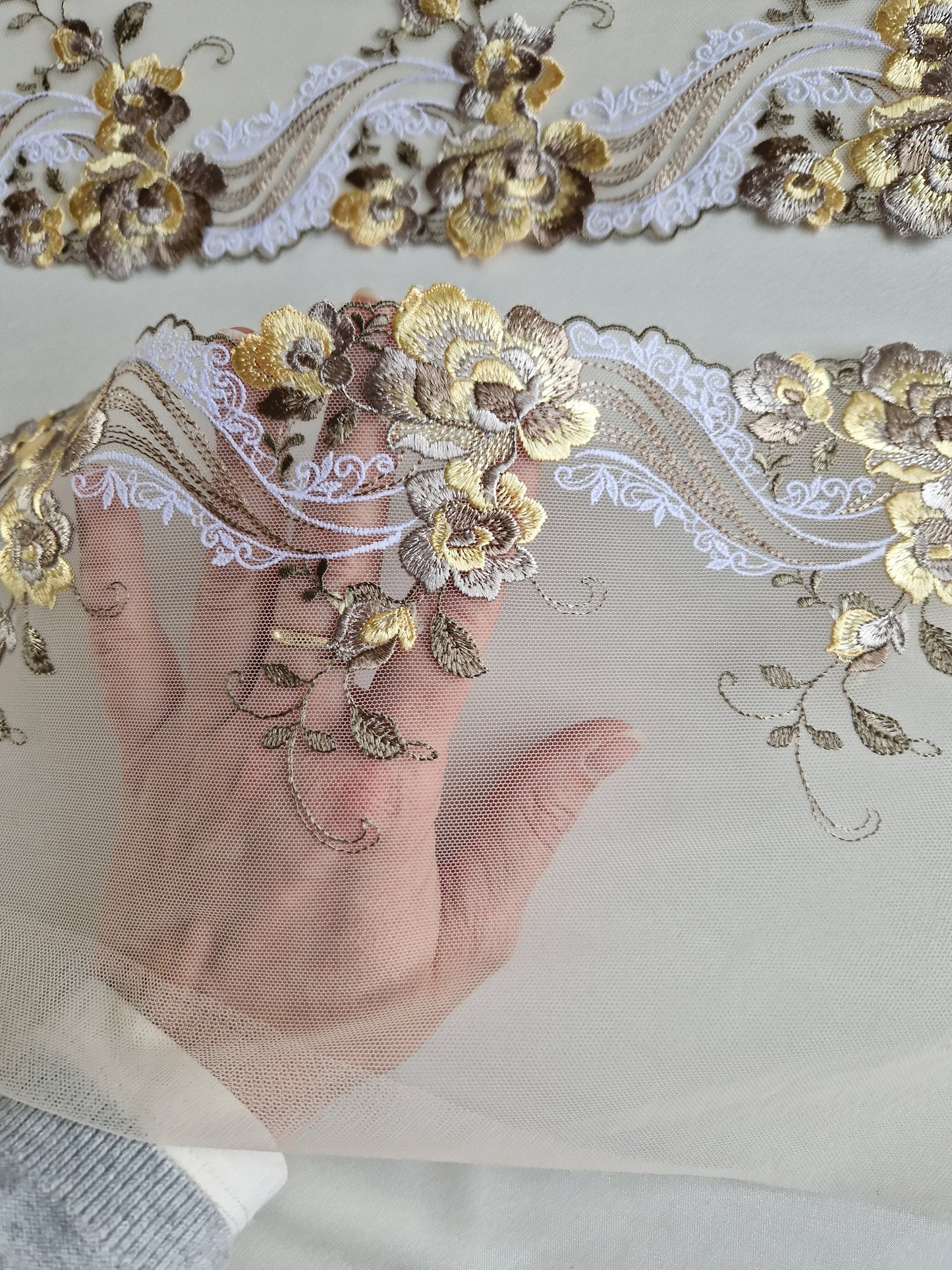 2024-40 ecru tule kant met bloemen in zacht geel en taupe.
