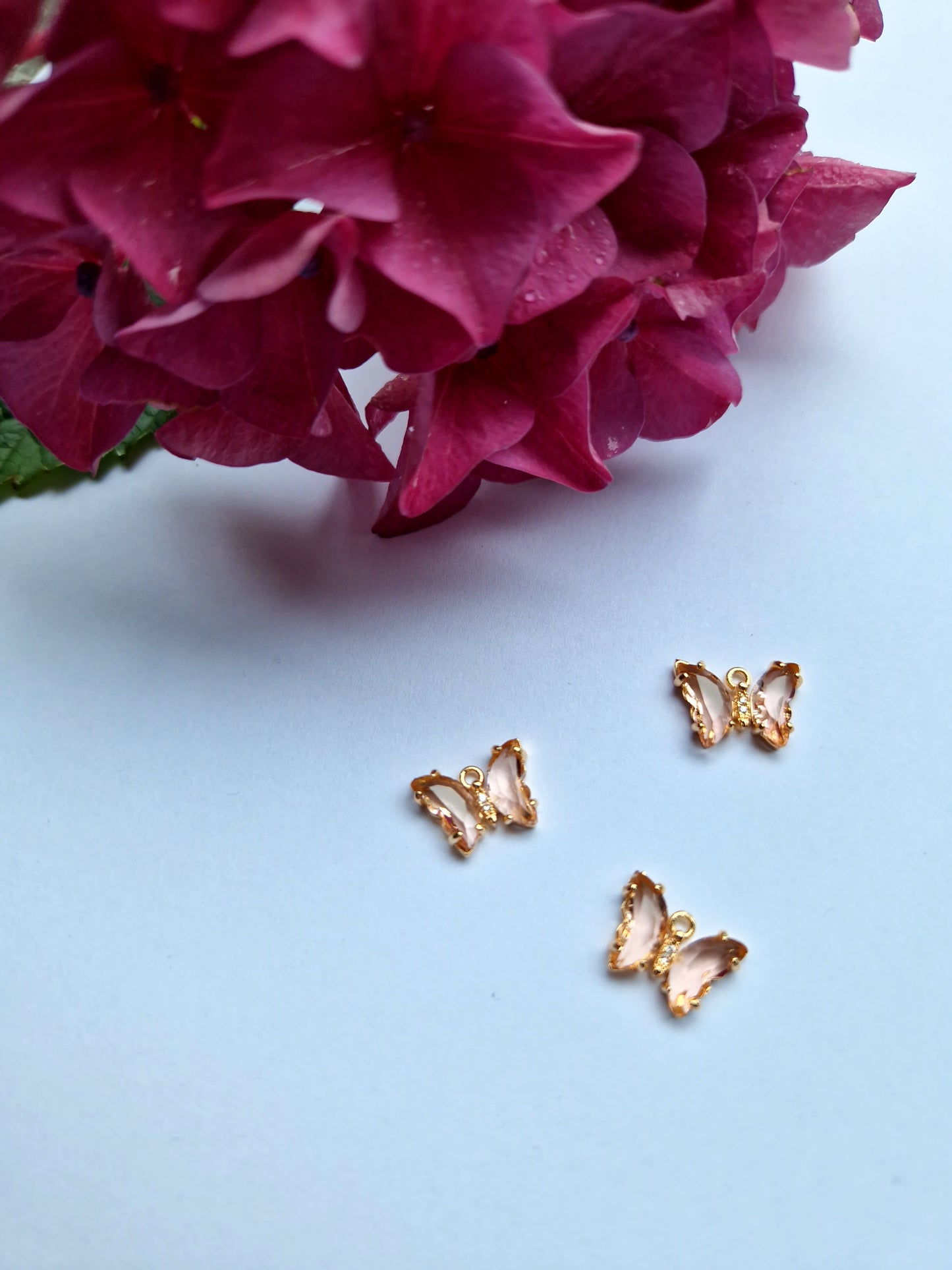 Goudkleurig bedeltje met lichtroze zirconia + ingelegde zirconiatjes in het lijfje