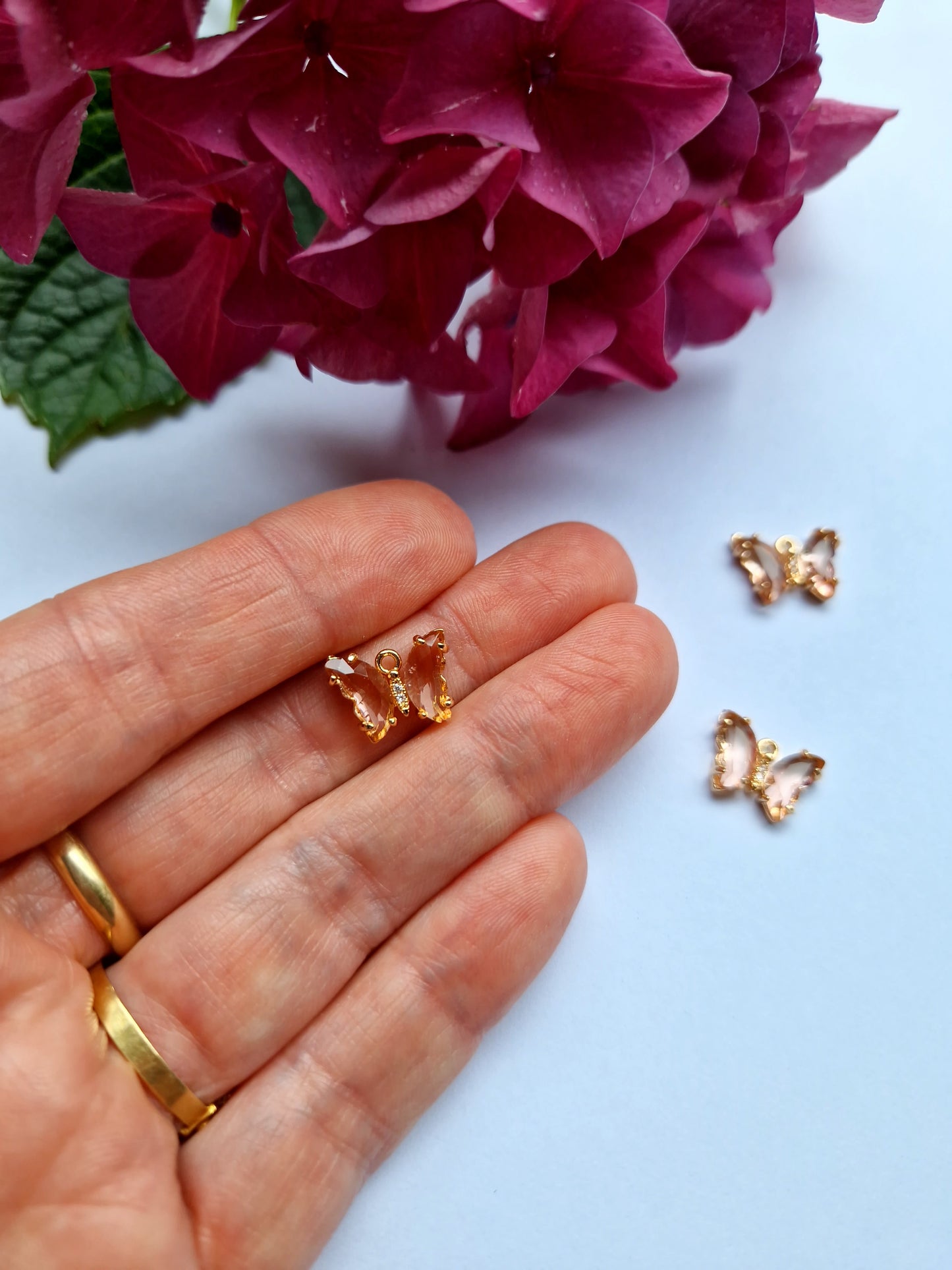 Goudkleurig bedeltje met lichtroze zirconia + ingelegde zirconiatjes in het lijfje