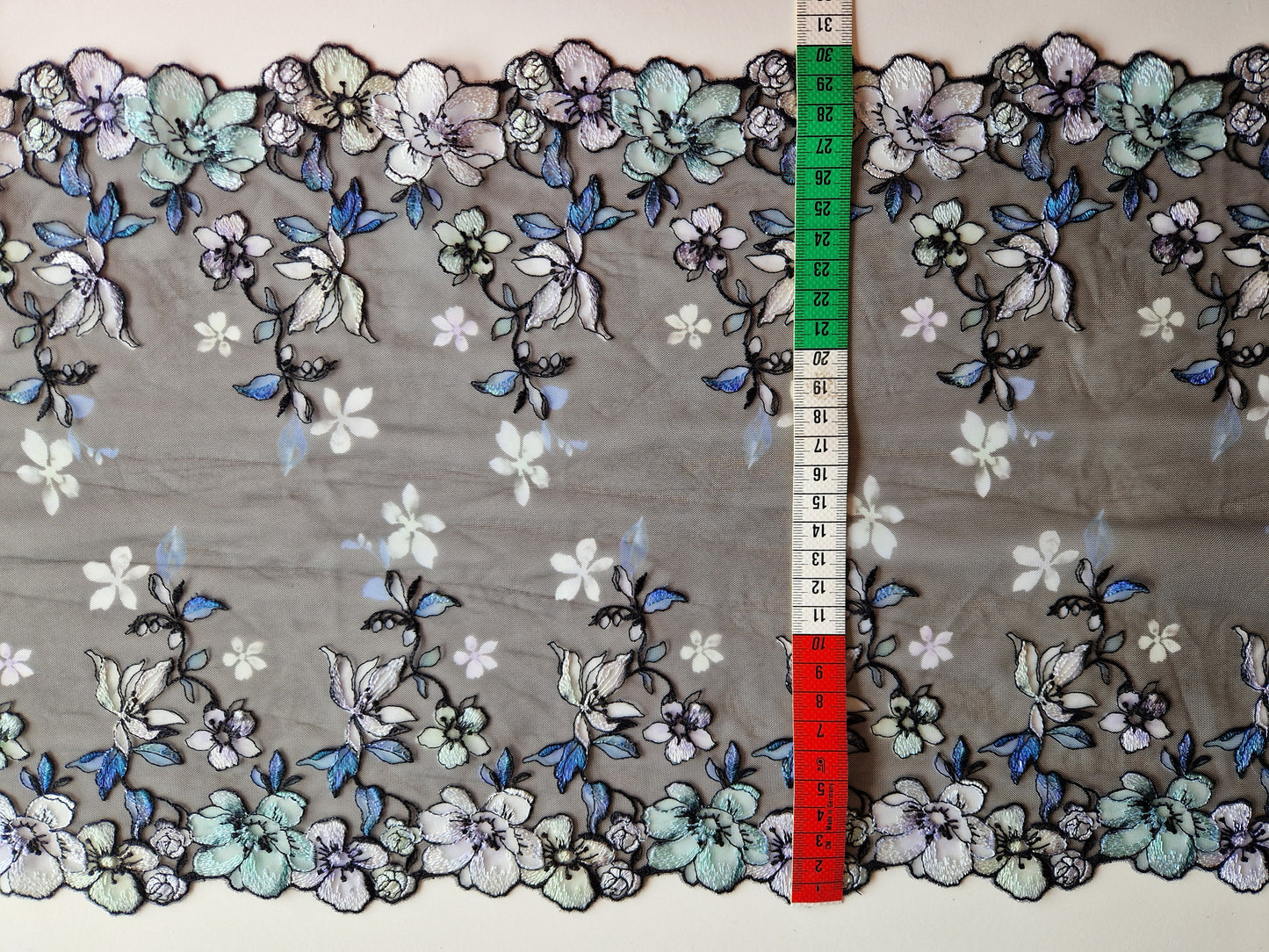 2024-118 Zwart tule kant met "glas in lood" bloemen look omlijst met zilverkleurig lurex draad.