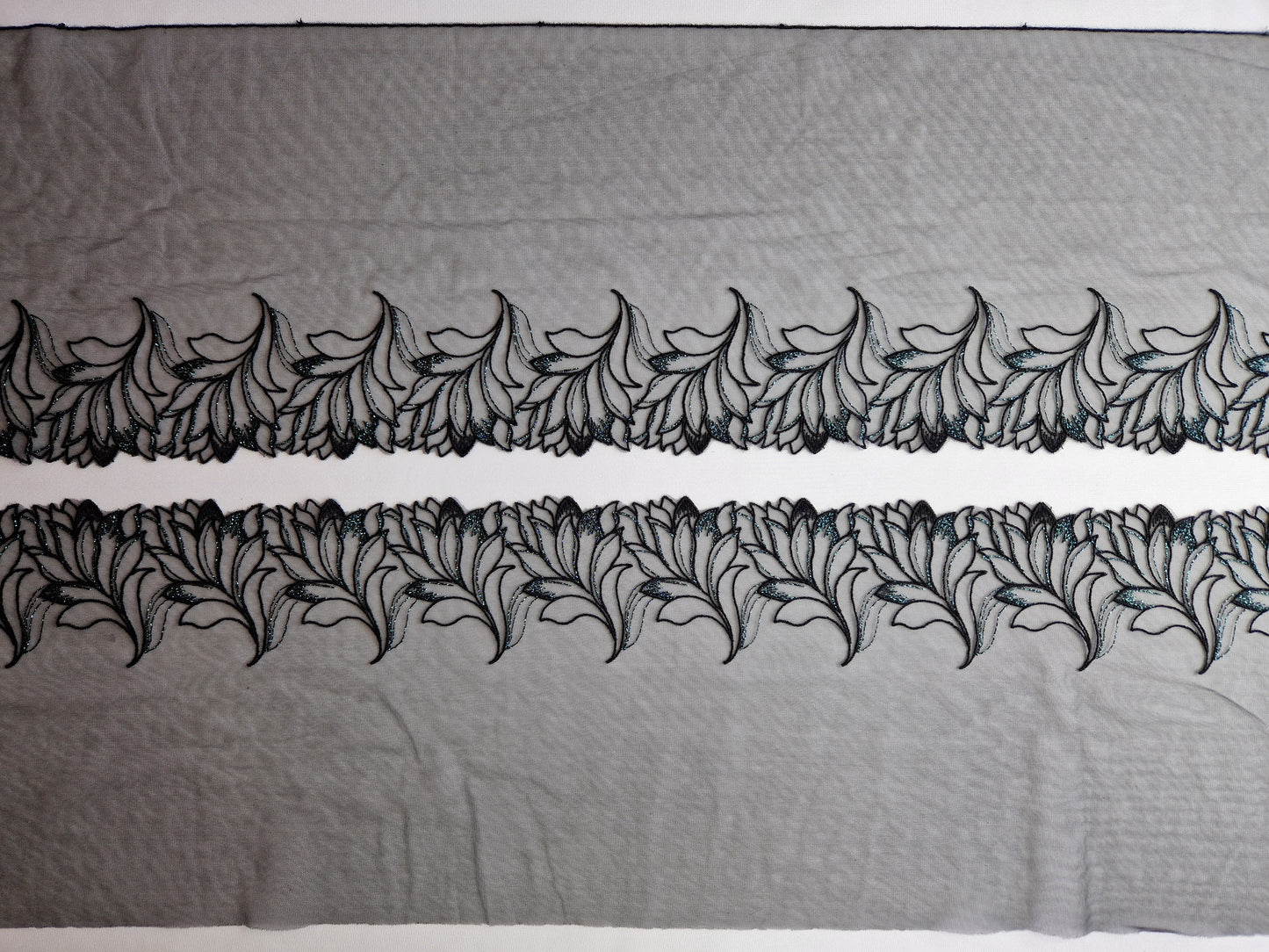 2024-146 Zwart tule kant met abstract geborduurde blaadjes voorzien van lichtblauw lurex draad