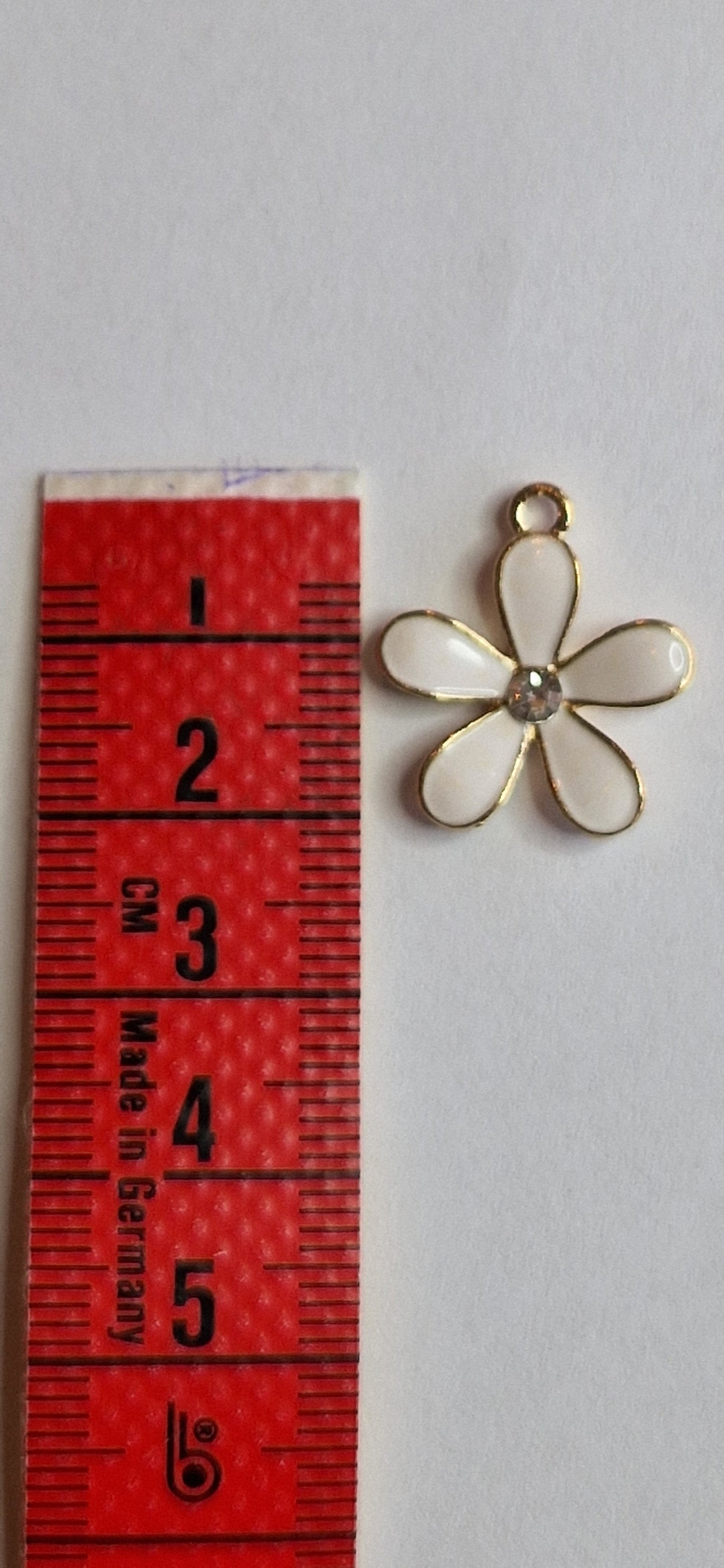 goudkleurig bedeltje van bloem met zirconia hartje en met wit emaille ingelegde blaadjes