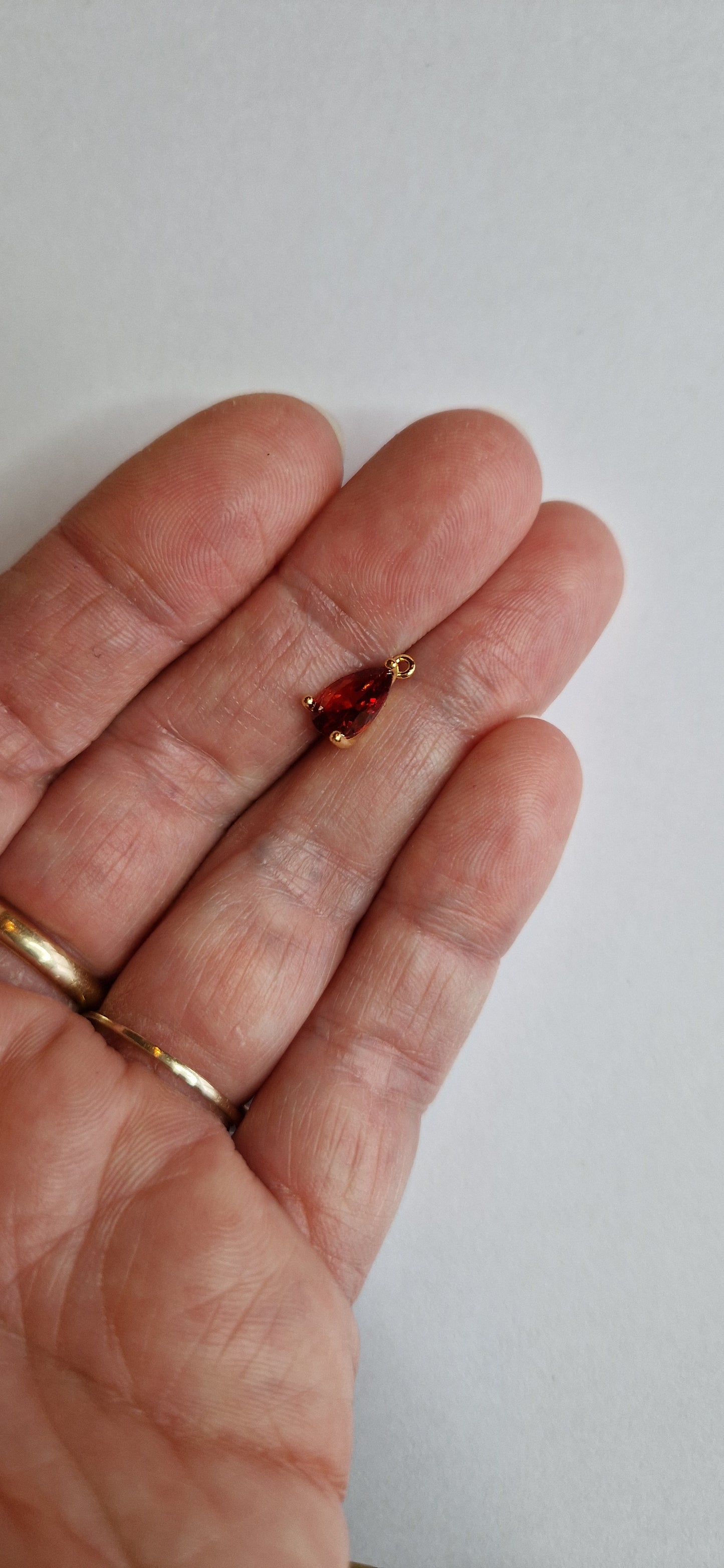 18k verguld bedeltje met roodoranje zirconia