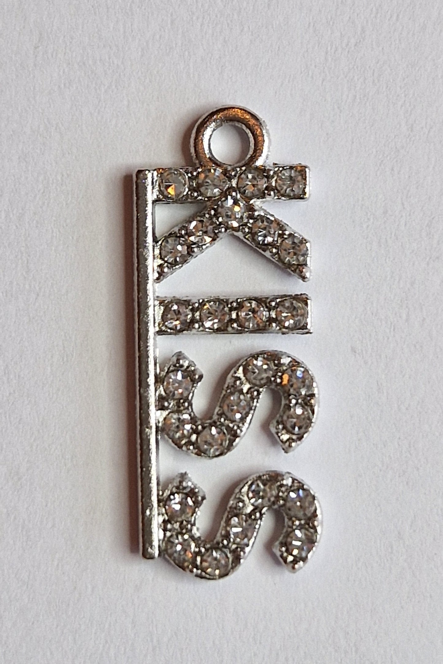 Zilver kleurig bedeltje met "KISS" in zirconiatjes