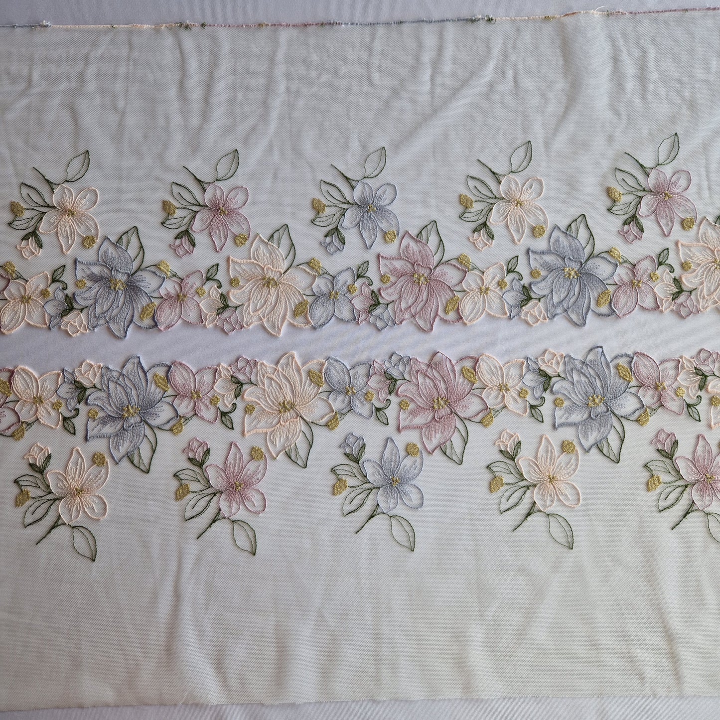 2025-49 wit tule kant met lelies in pastelkleuren voorzien van goudkleurig lurex draad