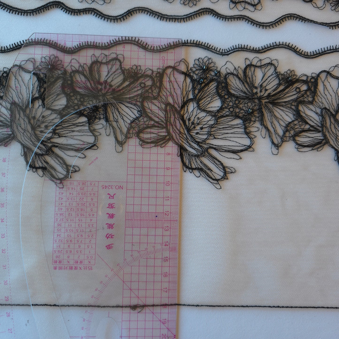 2025-90 beige tule kant met geborduurde bloemen in zwarte lineart voorzien van glaskraaltjes