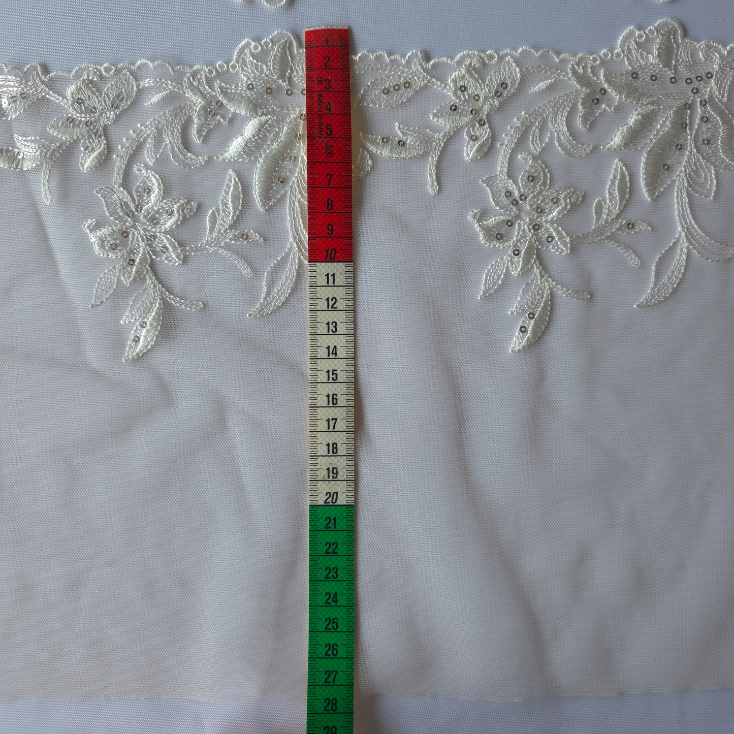 2025-113 peach kleurig tule kant met geborduurde witte lelies voorzien van zilverkleurige pailletten