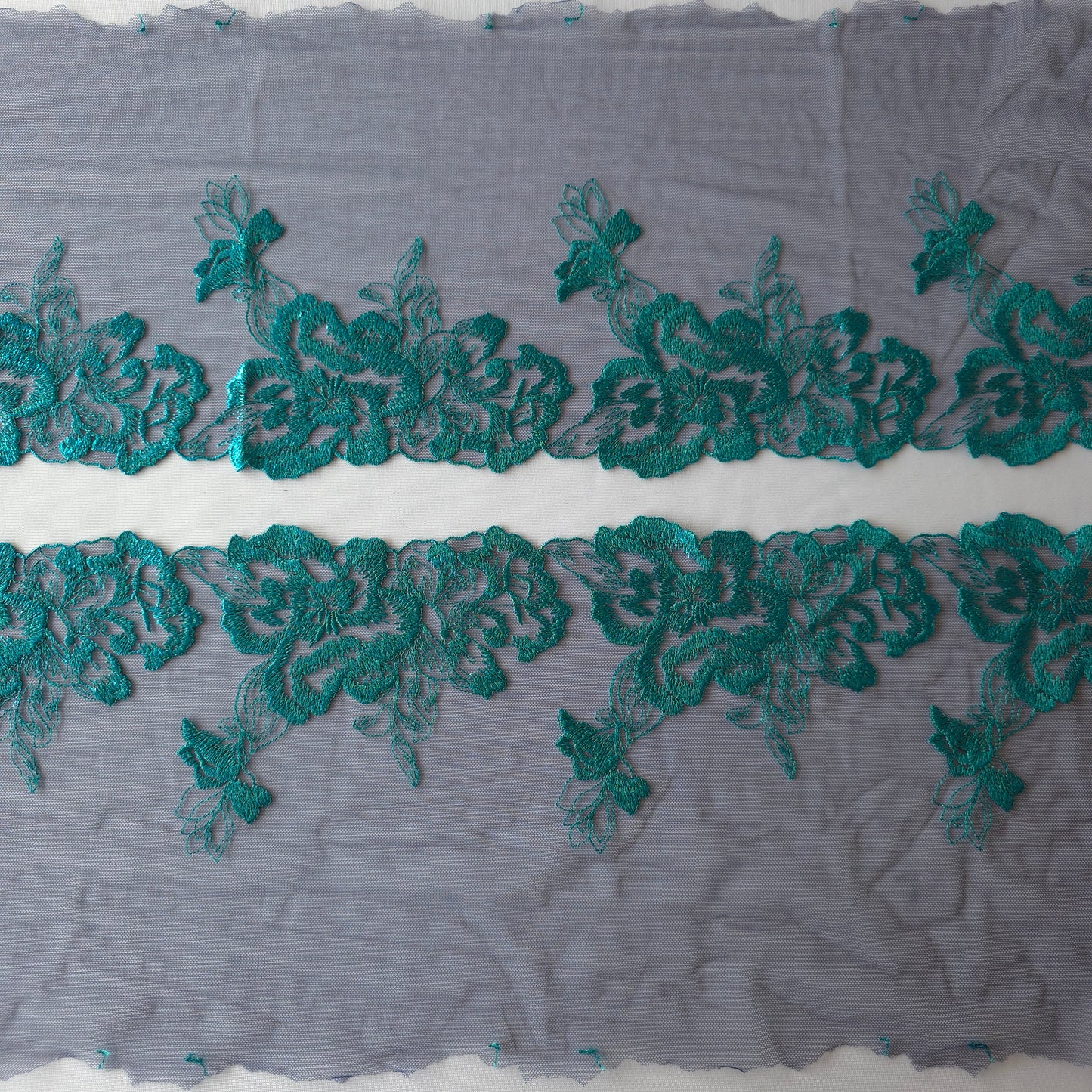 2025-114 donkerblauw tule kan met azuurblauw geborduurde bloemen voorzien van folieprint.