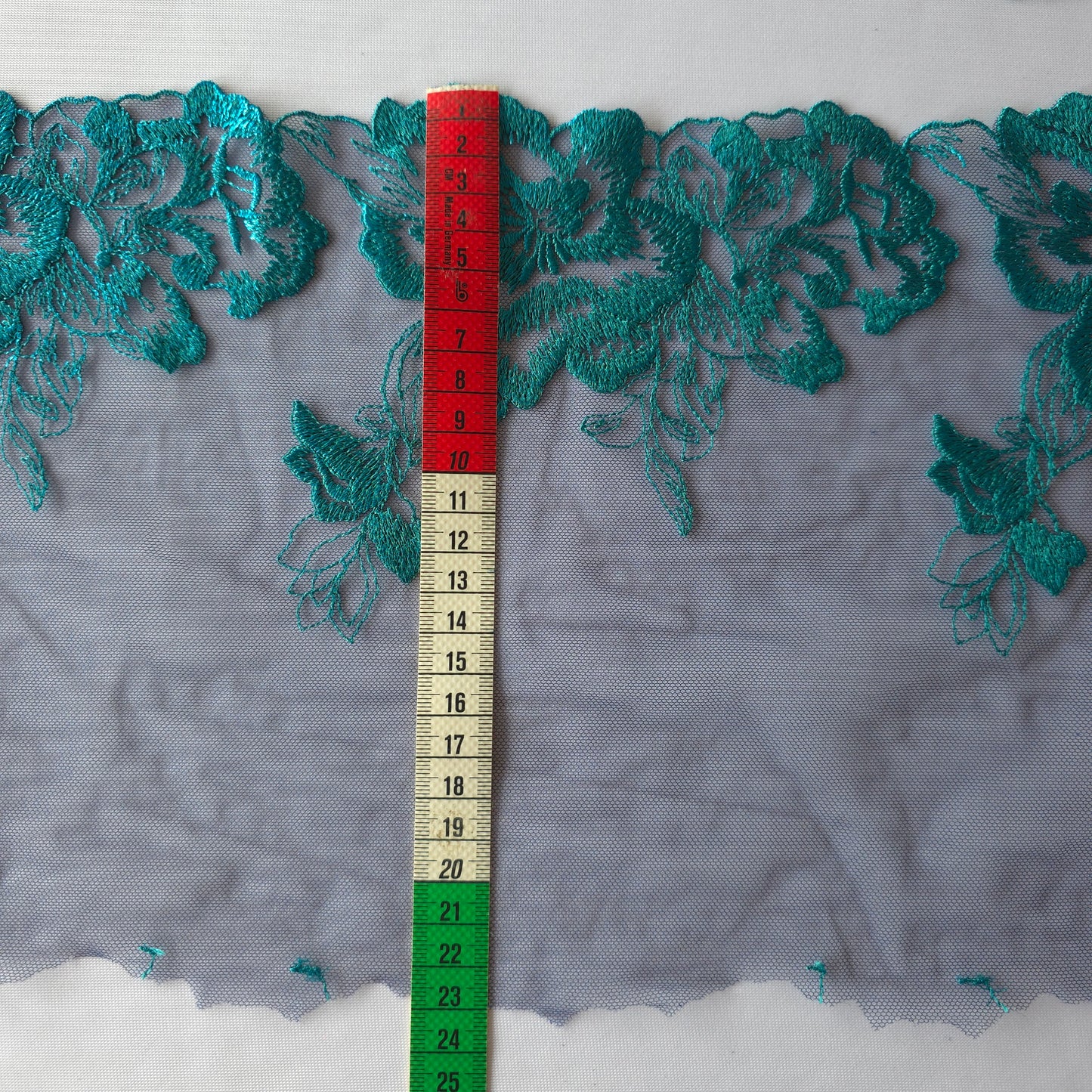 2025-114 donkerblauw tule kan met azuurblauw geborduurde bloemen voorzien van folieprint.