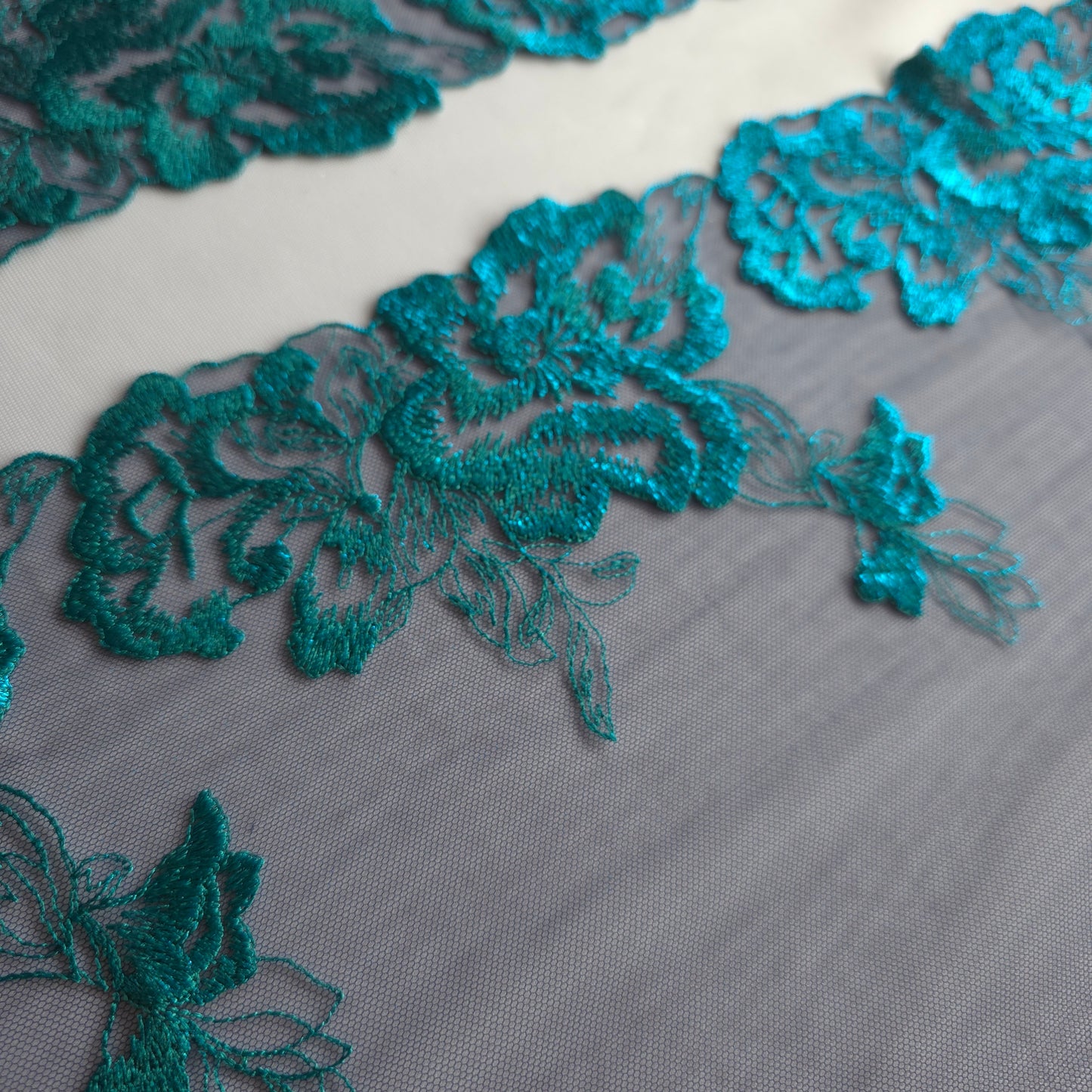 2025-114 donkerblauw tule kan met azuurblauw geborduurde bloemen voorzien van folieprint.