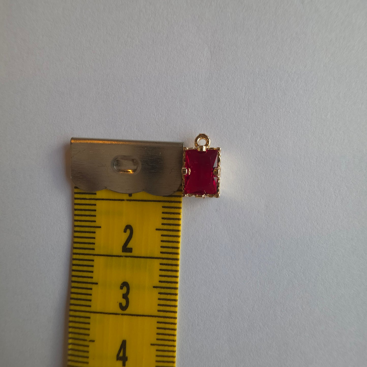 goudkleurig bedeltje ingezet met rechthoekig groen zirkoon