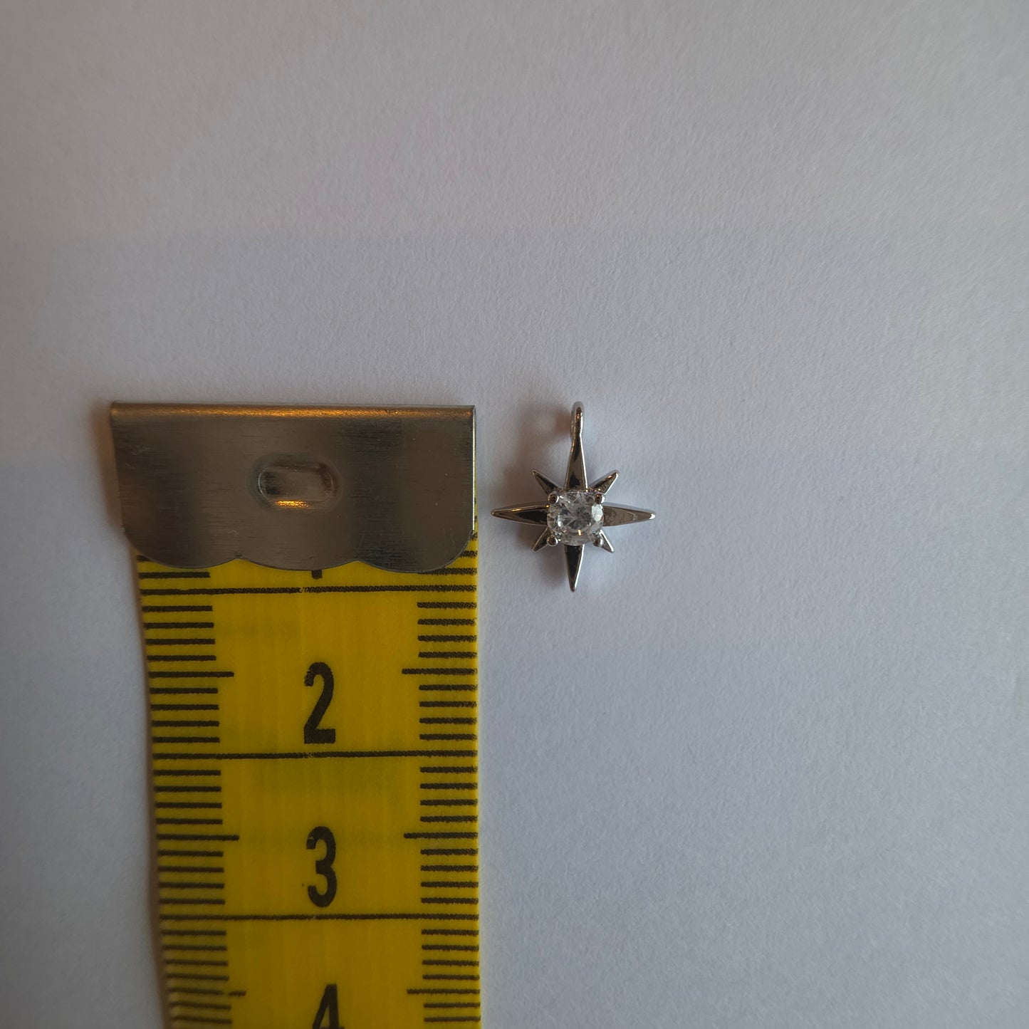 zilverkleurig bedeltje van sterretje met zirkoontje