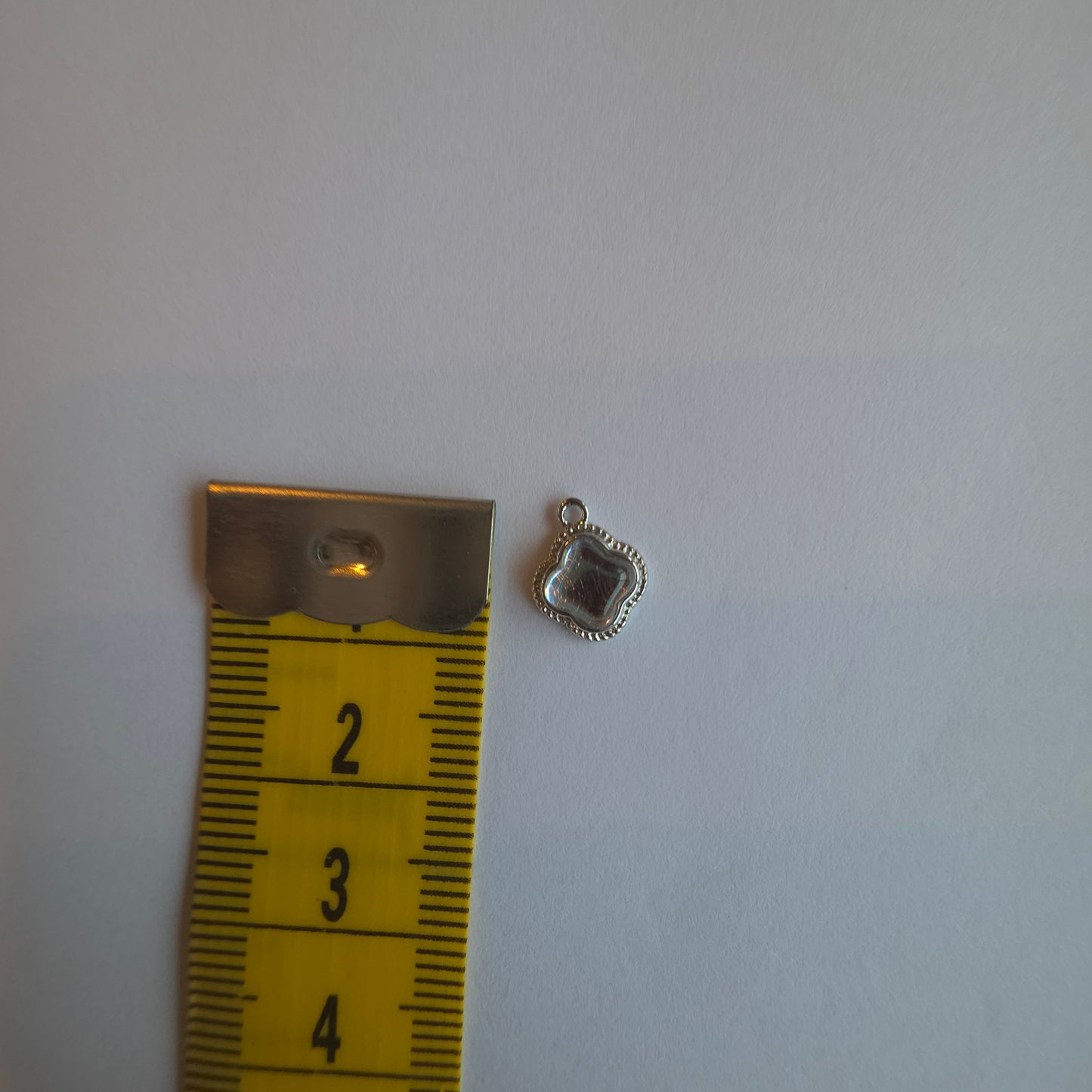 zilverkleurig bedeltje met iriserend steentje