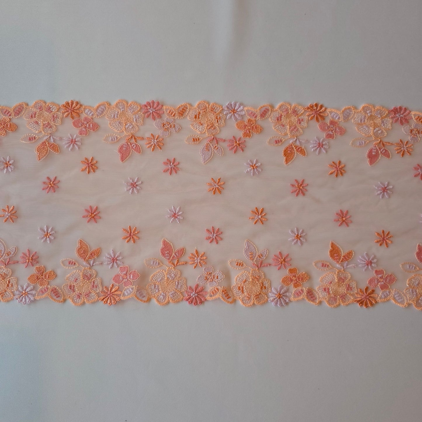 2026-13 lichtroze geborduurd stretchkant met bloemetjes in roze, peach, licht oranje en lila