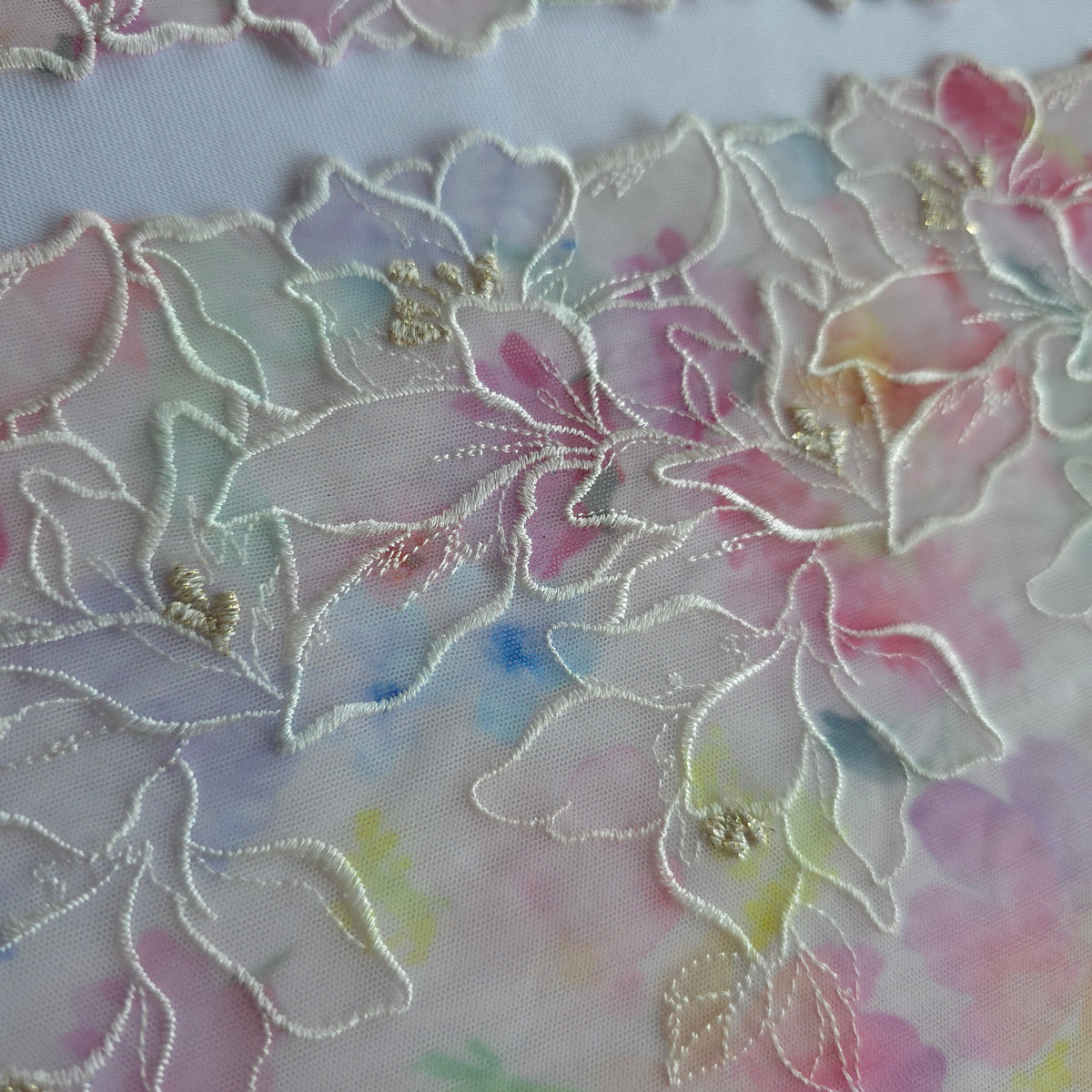 2026-85 roomwit stretchmesh kant met kleurrijke bloemenprint en geborduurde bloemen voorzien van goudkleurig lurexdraadzien
