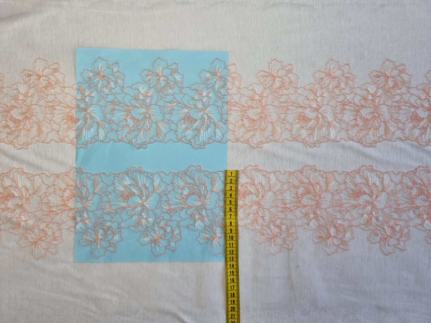 Wit tule kant met peach kleurig bloemen borduursel.