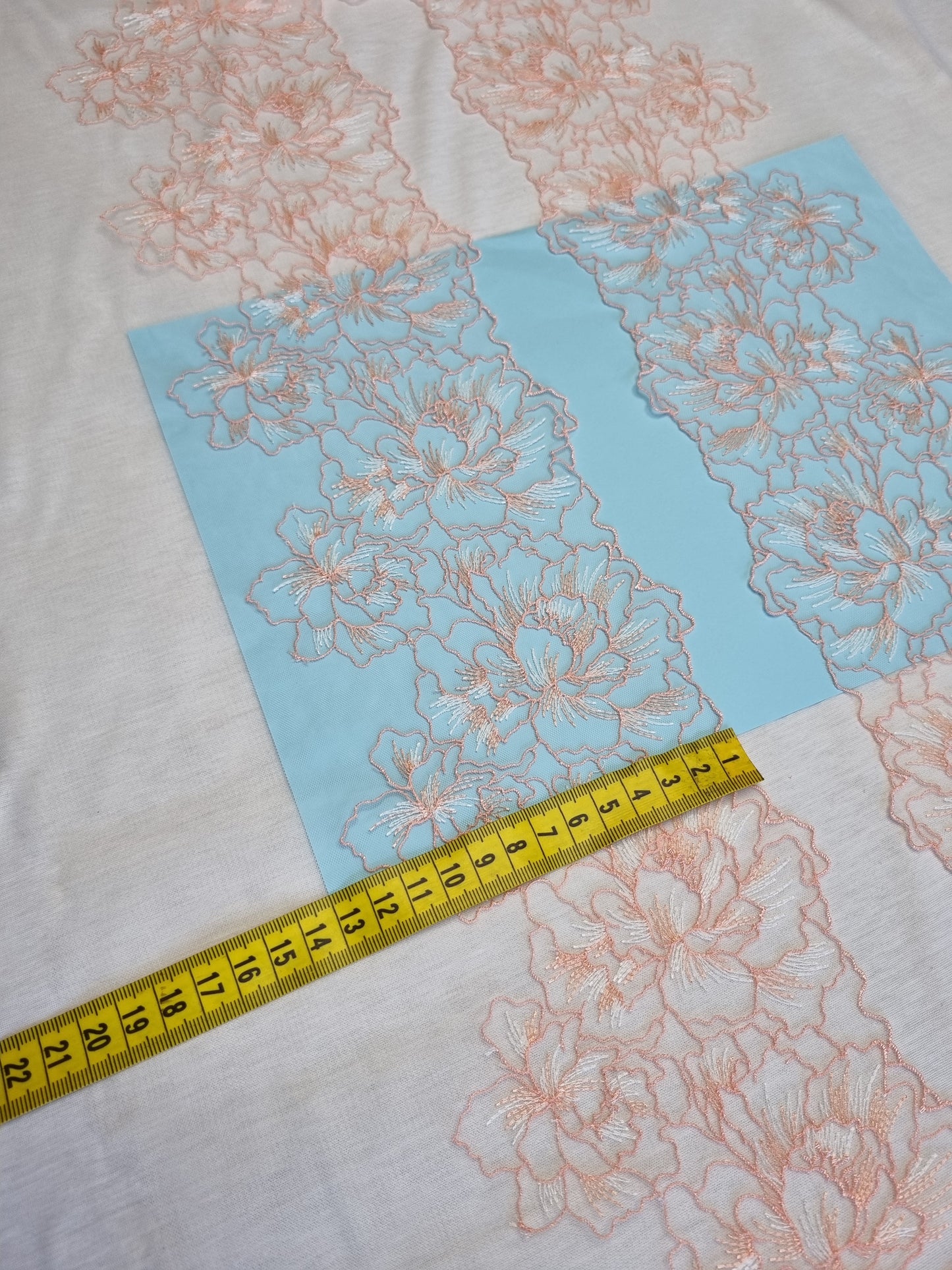 Wit tule kant met peach kleurig bloemen borduursel.