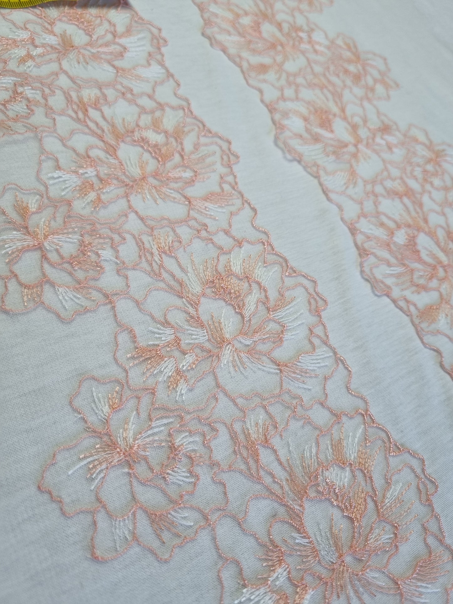 Wit tule kant met peach kleurig bloemen borduursel.