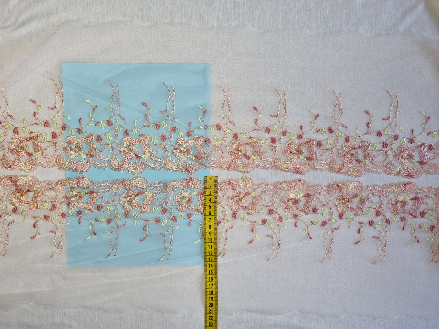 Zacht roze tule kant met 's zomers bloemen borduursel
