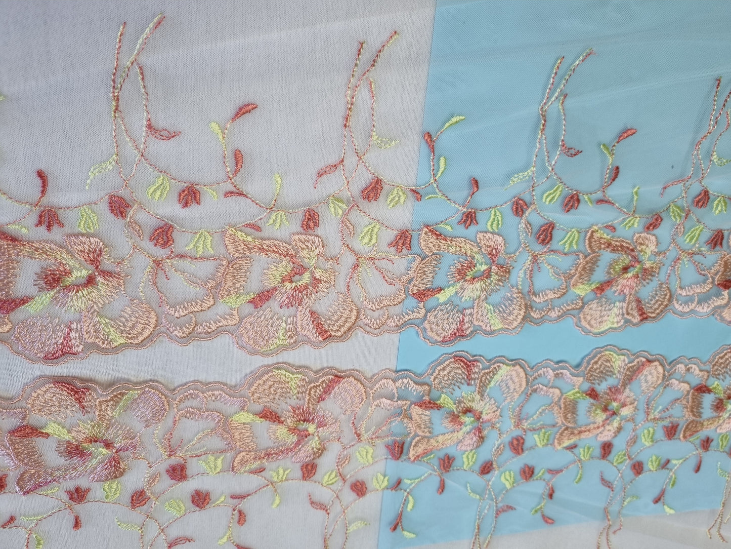 Zacht roze tule kant met 's zomers bloemen borduursel