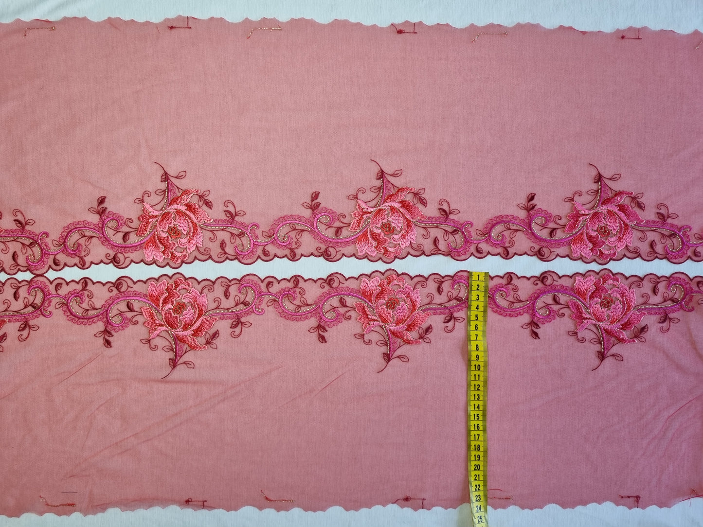 Rood tule kant met roze geborduurde bloemen.