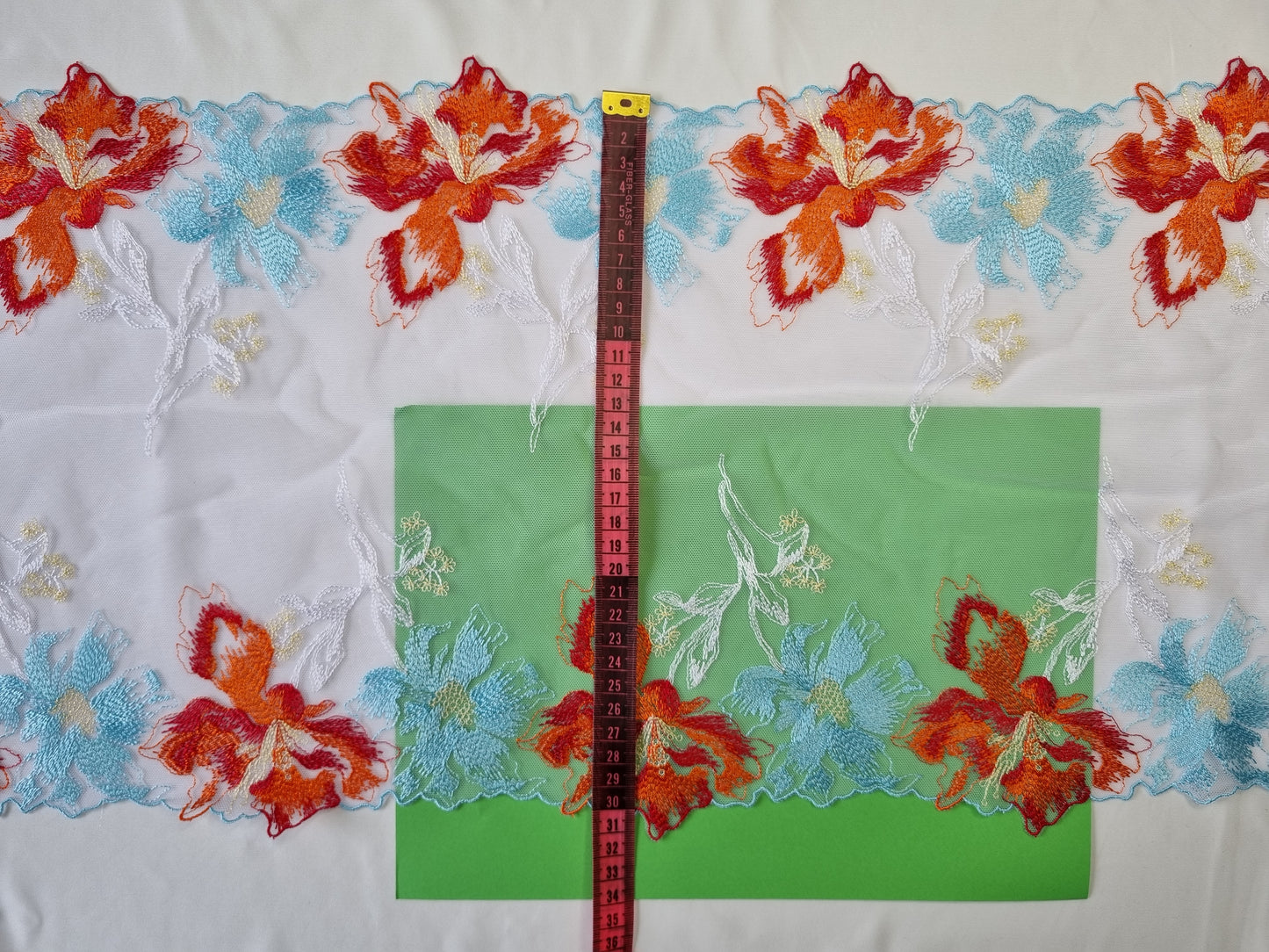Wit tule kant met kleurrijk bloemen borduursel