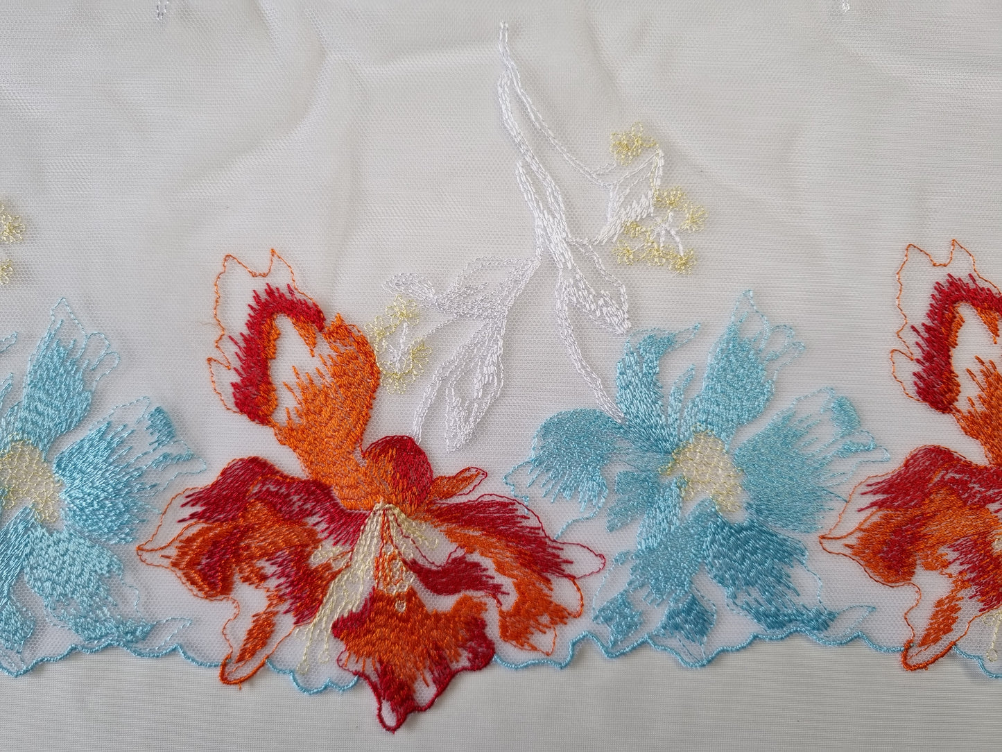 Wit tule kant met kleurrijk bloemen borduursel