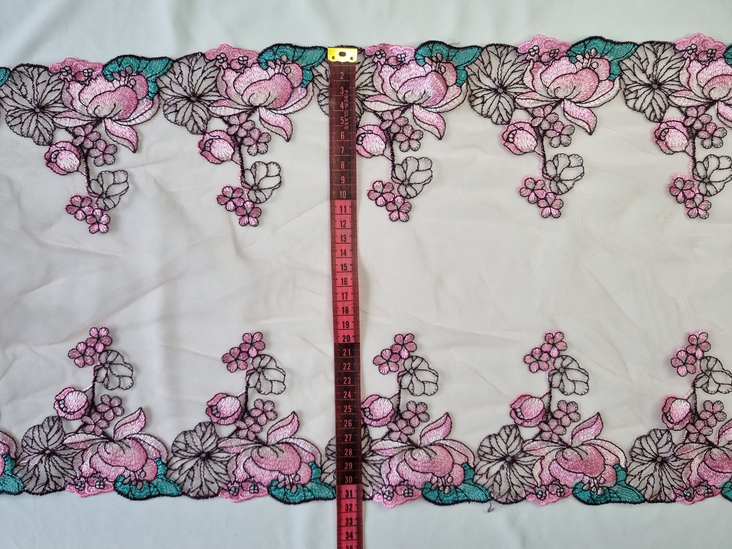 Licht roze tule kant met geborduurde waterlelies