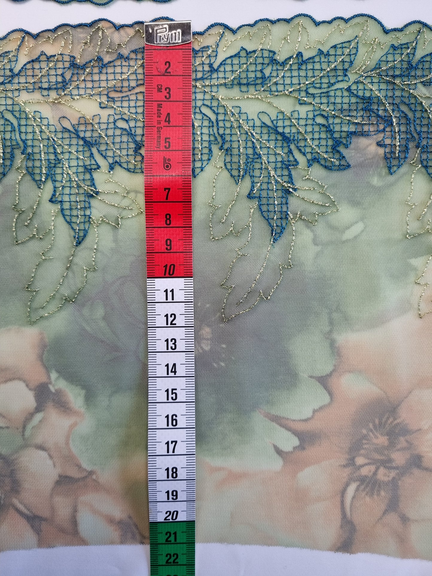 Groen tule kant met geborduurde abstracte blaadjes.