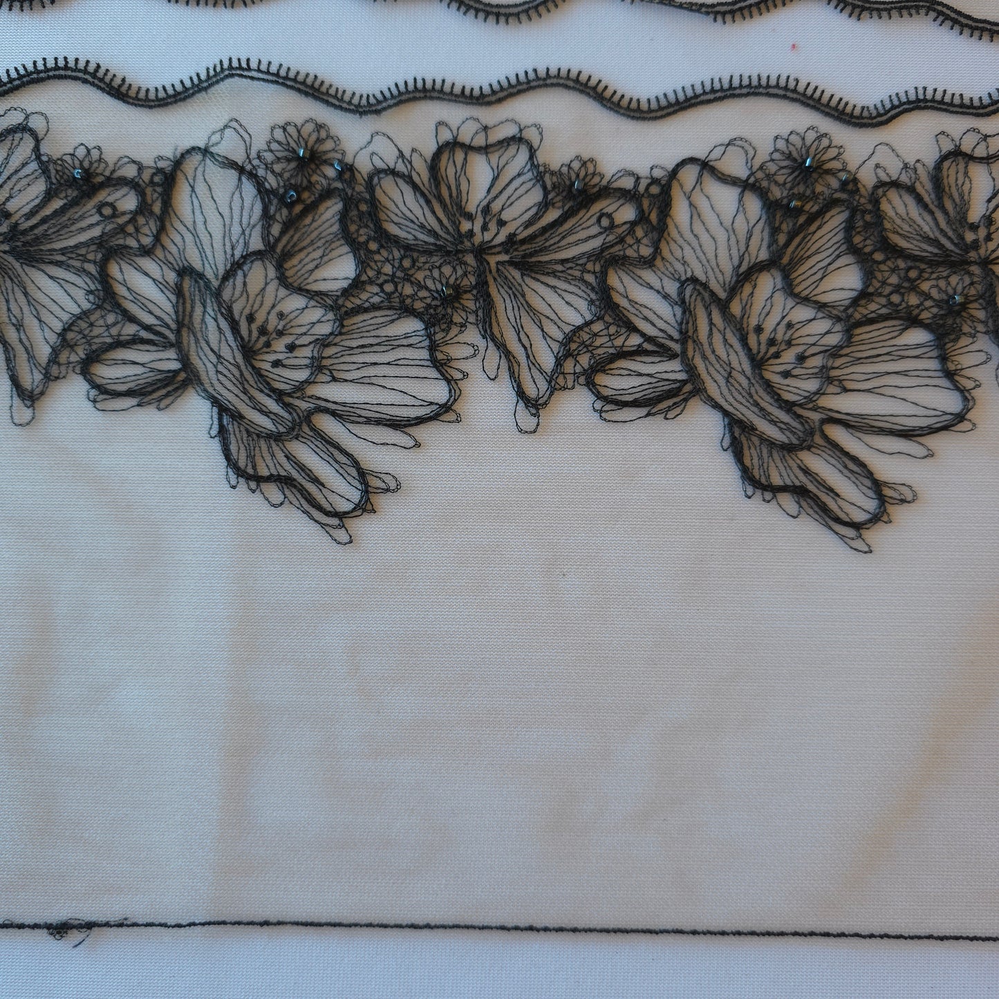 2025-90 beige tule kant met geborduurde bloemen in zwarte lineart voorzien van glaskraaltjes
