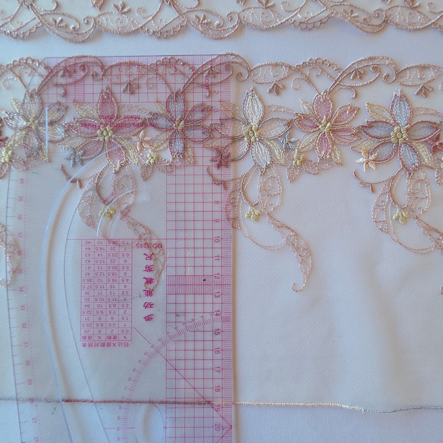 2025-96 wit tule kant met geborduurde bloemen in taupe en paarstinten voorzien van goudkleurig lurexdraad