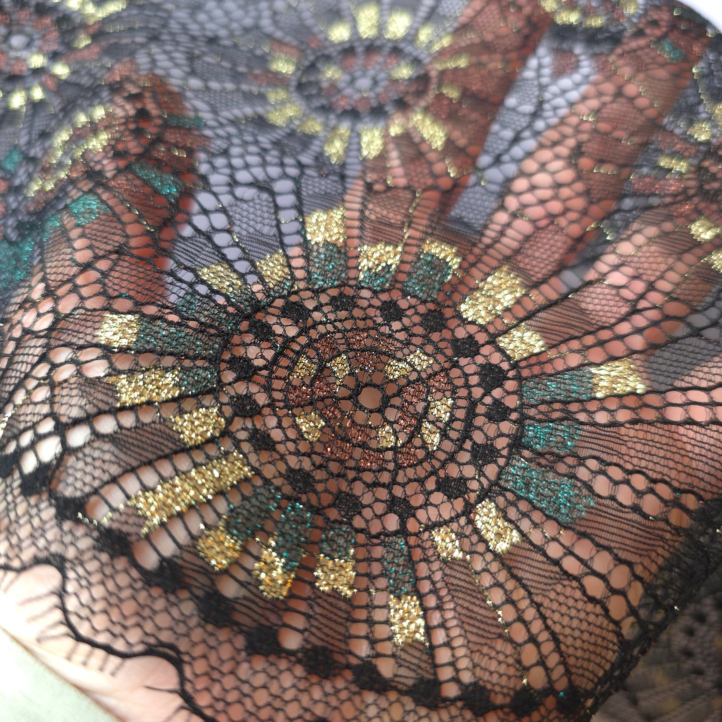 2025-101 zwart stretchkant met abstract vuurwerk voorzien van lurexgaren in goud, groen en bruin