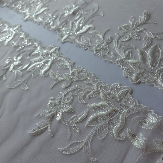 2025-113 peach kleurig tule kant met geborduurde witte lelies voorzien van zilverkleurige pailletten